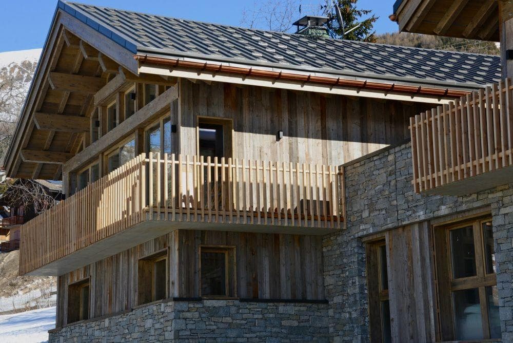 Chalet exterior featuring reclaimed wood siding and private wrap-around balcony