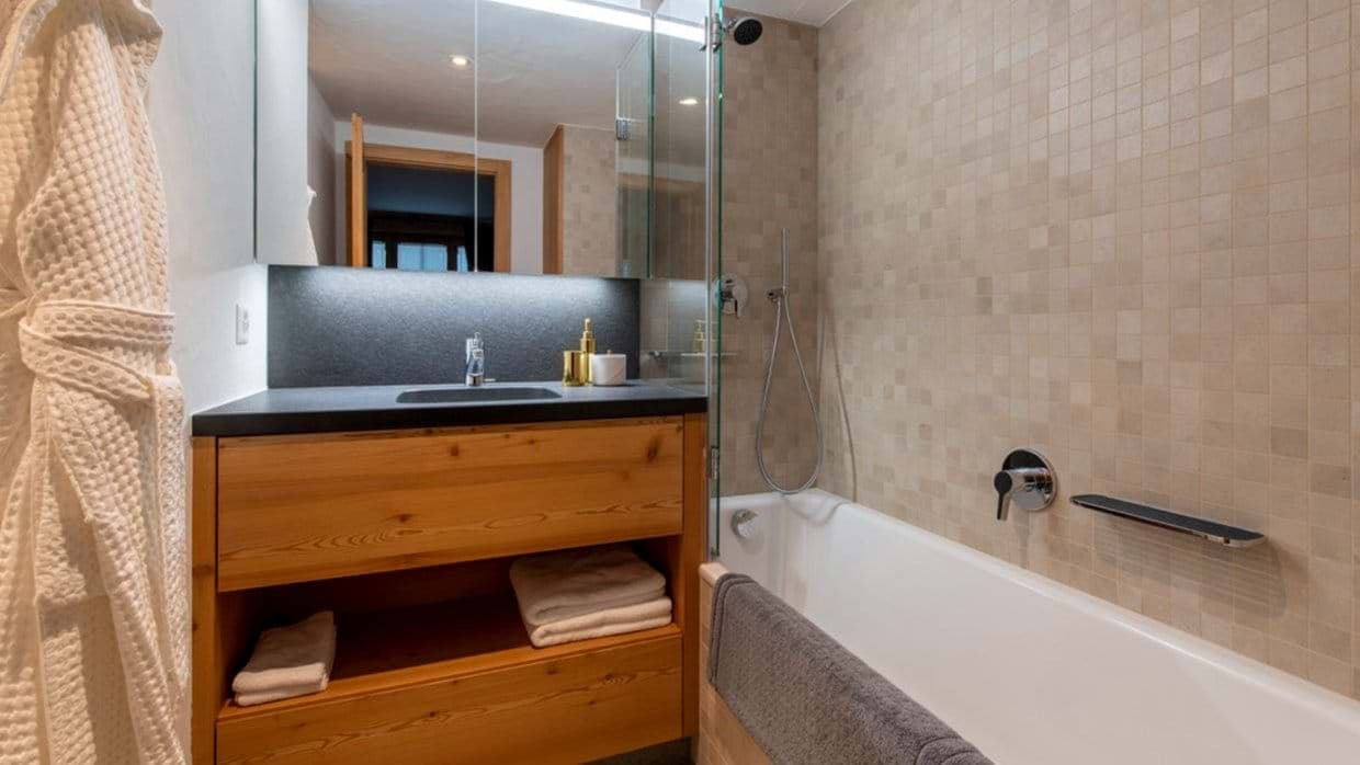 Bathroom with soaking tub, handheld shower, and wood vanity