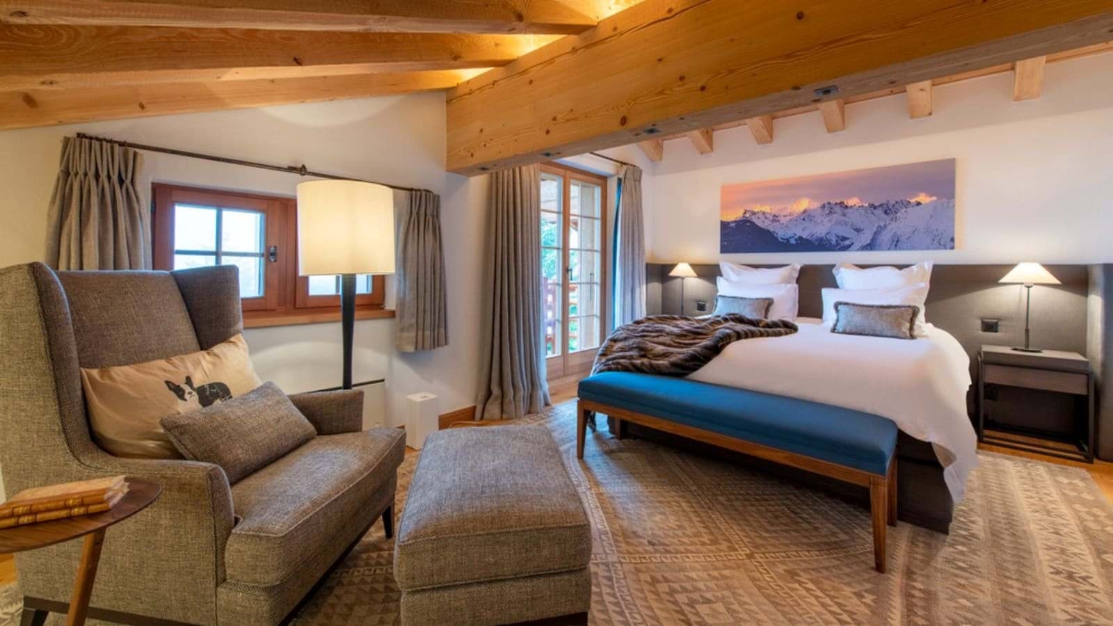 Bedroom with king bed, vaulted wood beams, and balcony access