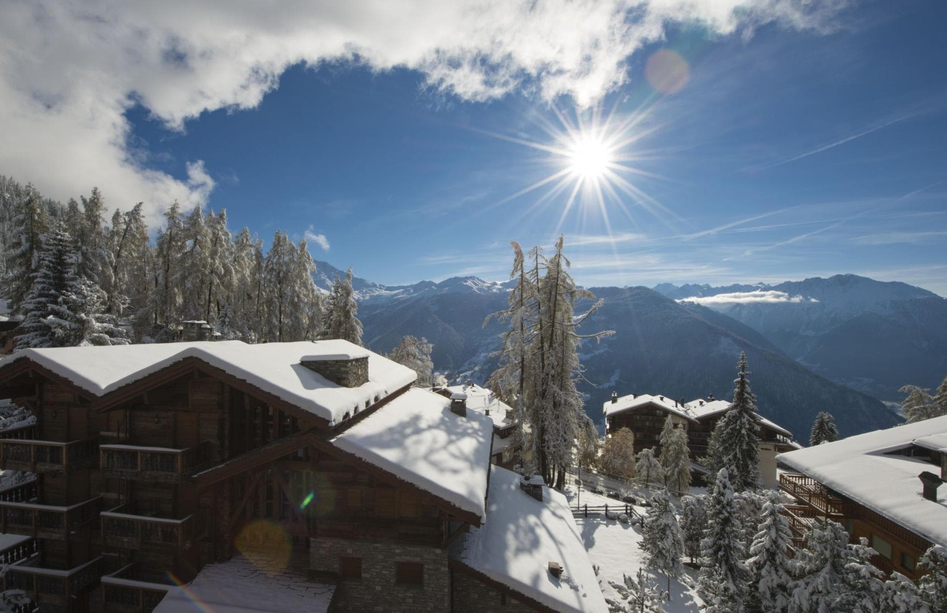 Ski resort view from balcony with sun exposure and mountain peaks
