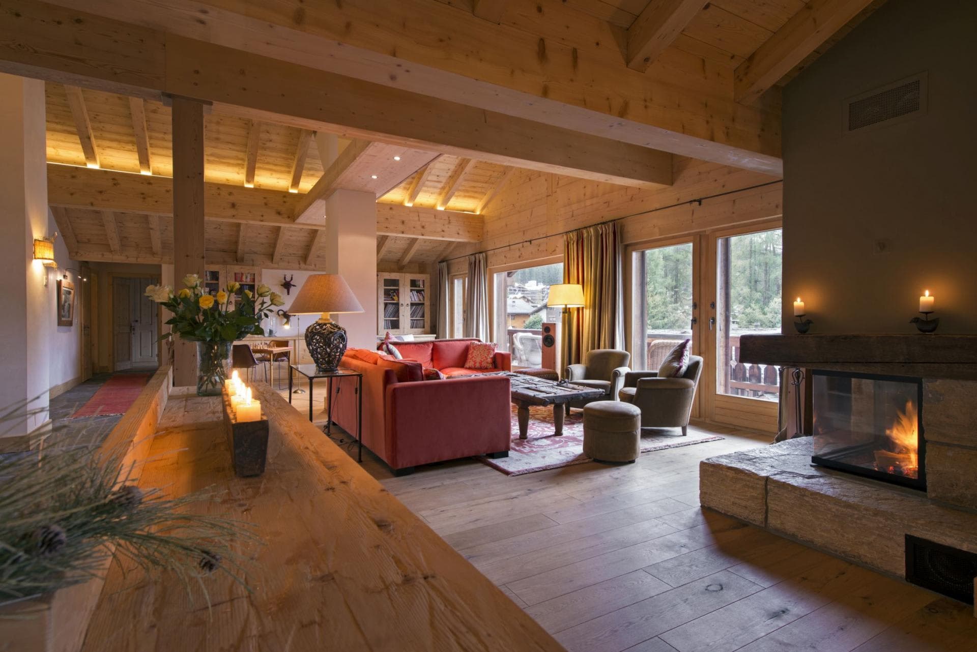 Living area with wood-burning fireplace and vaulted timber ceilings