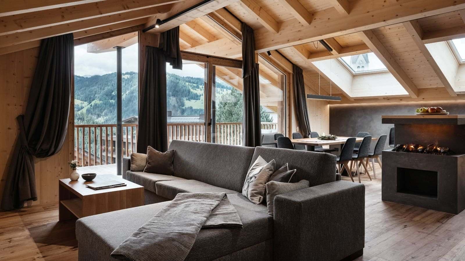 Open-concept living area with fireplace, terrace access, and mountain views