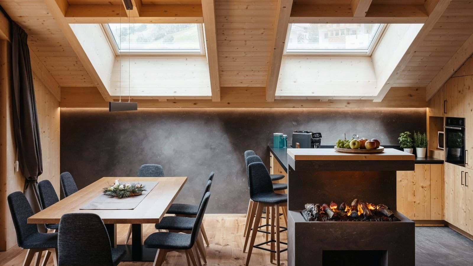 Dining area and kitchen with electric fireplace and skylight views