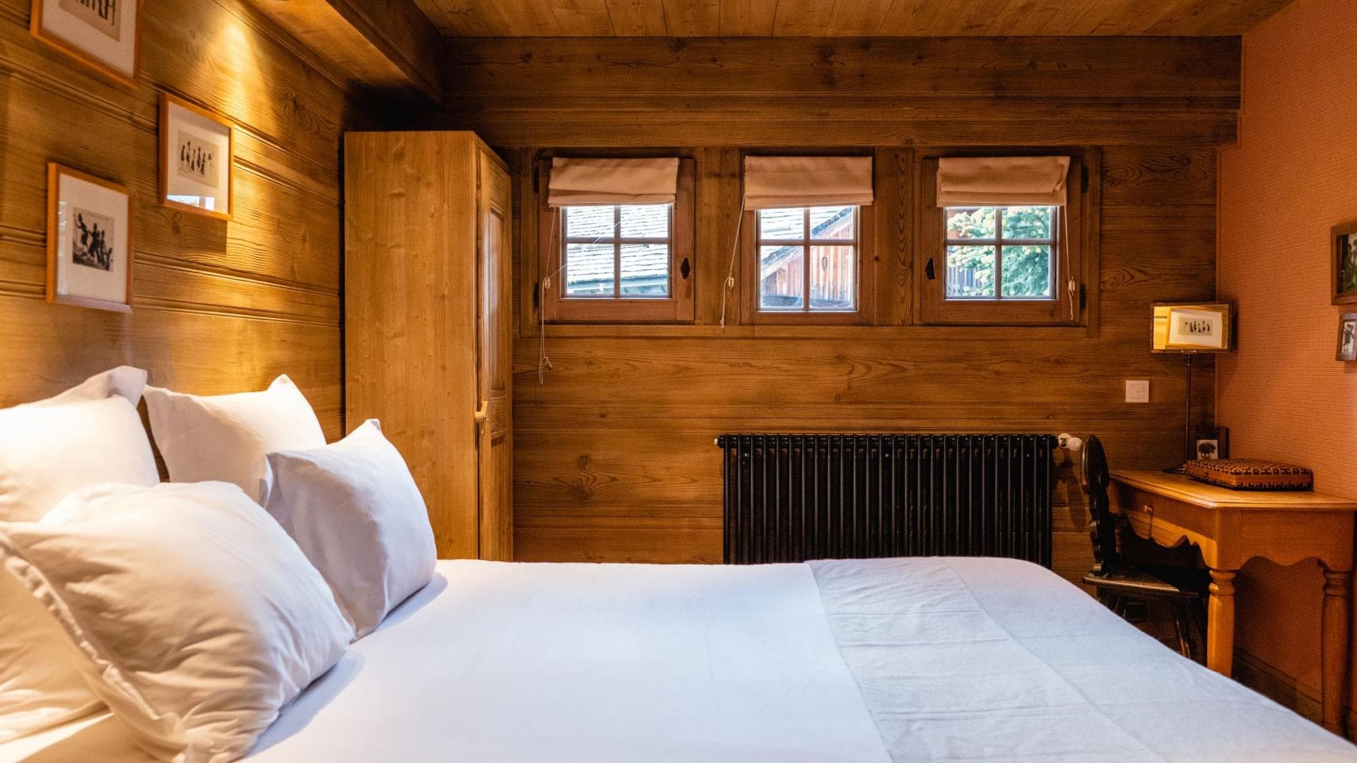 Guest bedroom with dedicated workspace and wood-paneled walls
