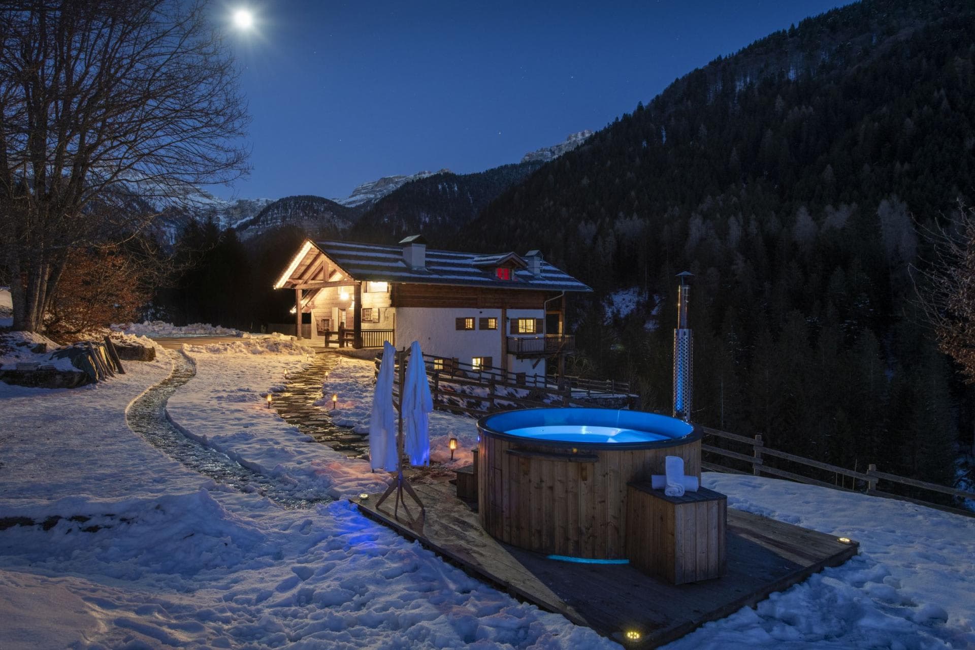 Wood-fired hot tub with mountain views and heated stone walkway
