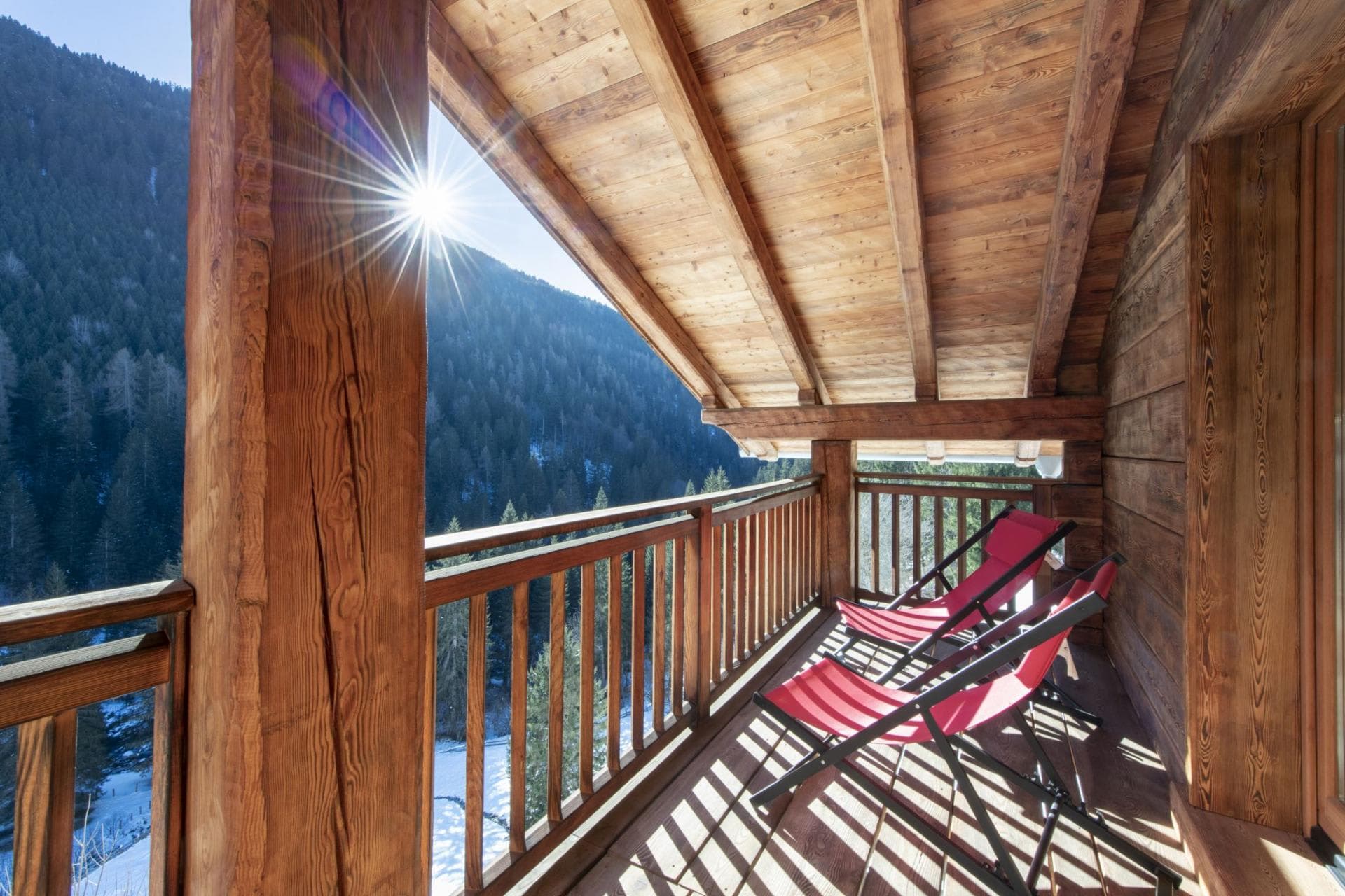 Covered balcony with lounge seating and forest valley views