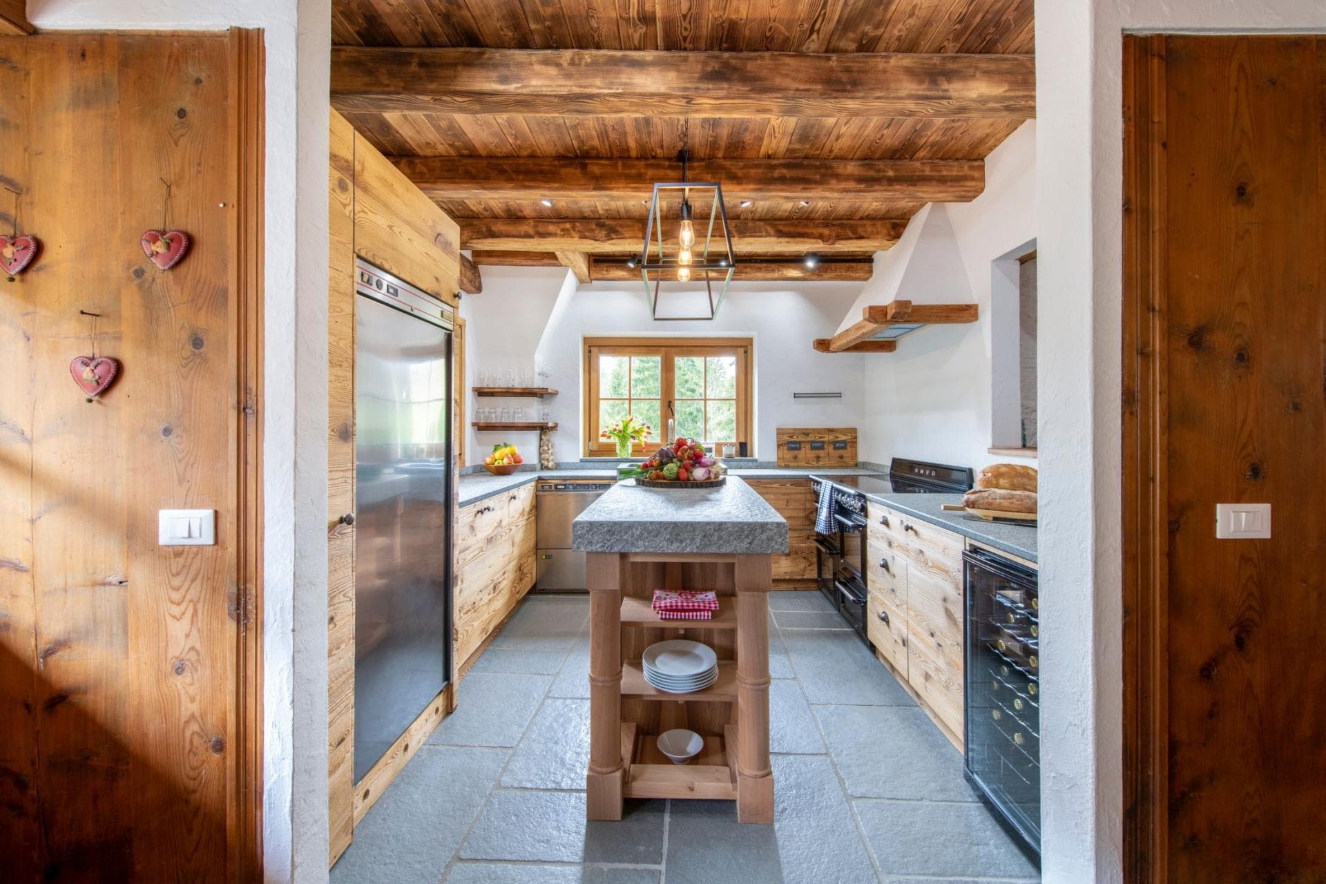 Kitchen with stone-topped island, Smeg range, and integrated wine cooler