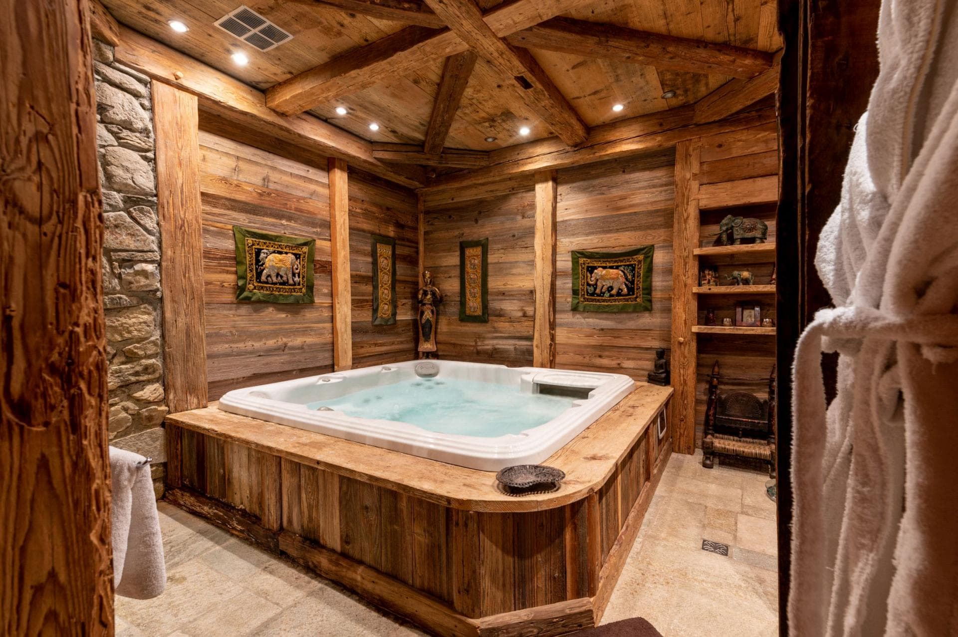 Indoor hot tub room with reclaimed wood walls and stone accents