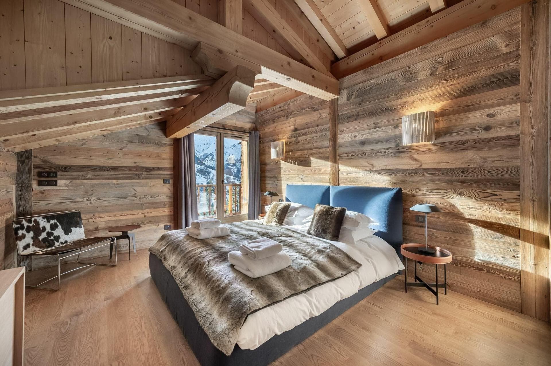 Wood-paneled bedroom with king bed and private balcony access