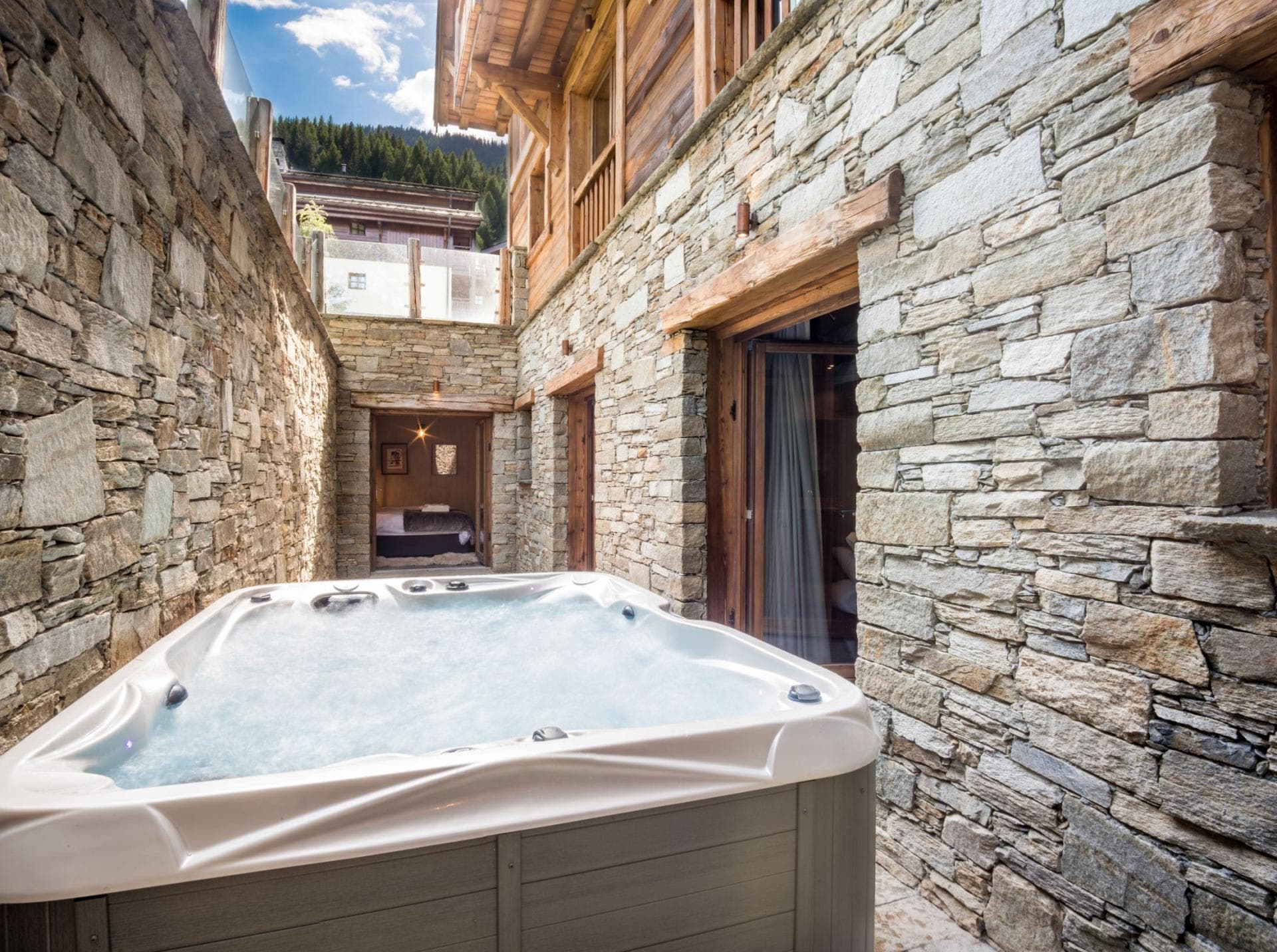 Private stone-walled terrace with 6-person hot tub and bedroom access