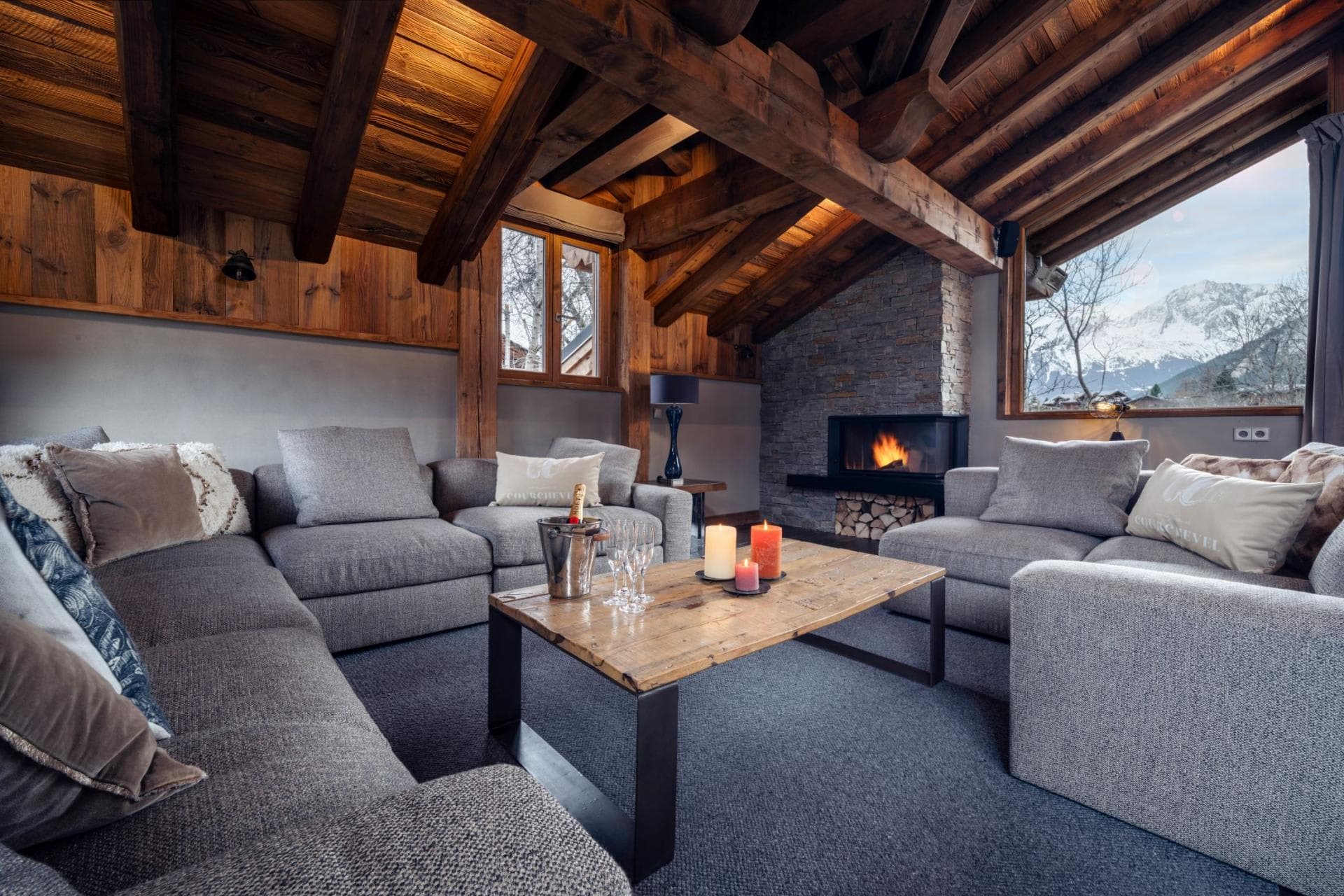 Living area with wood-burning fireplace and mountain peaks view