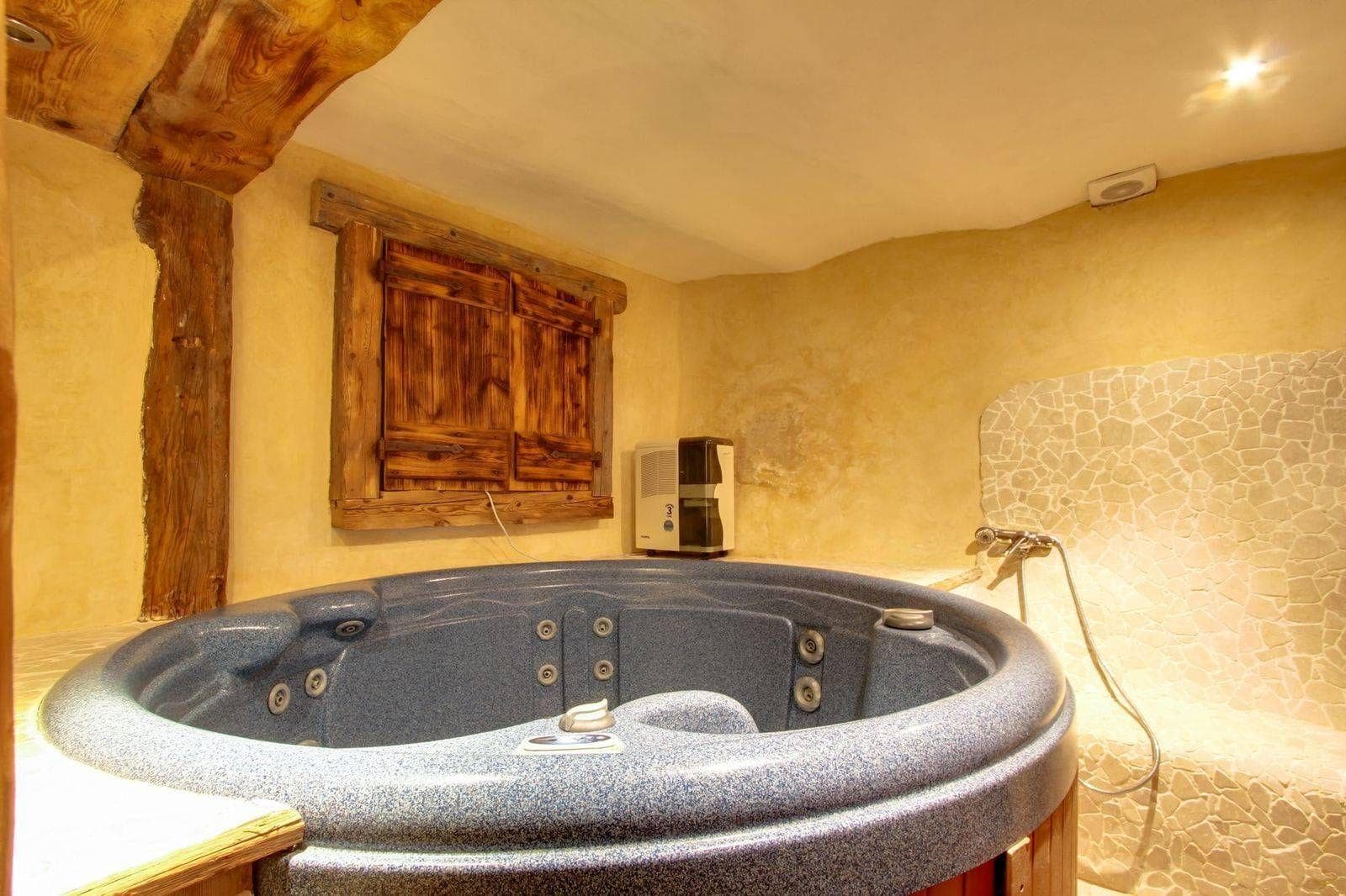 Indoor hot tub and stone-tiled walk-in shower area