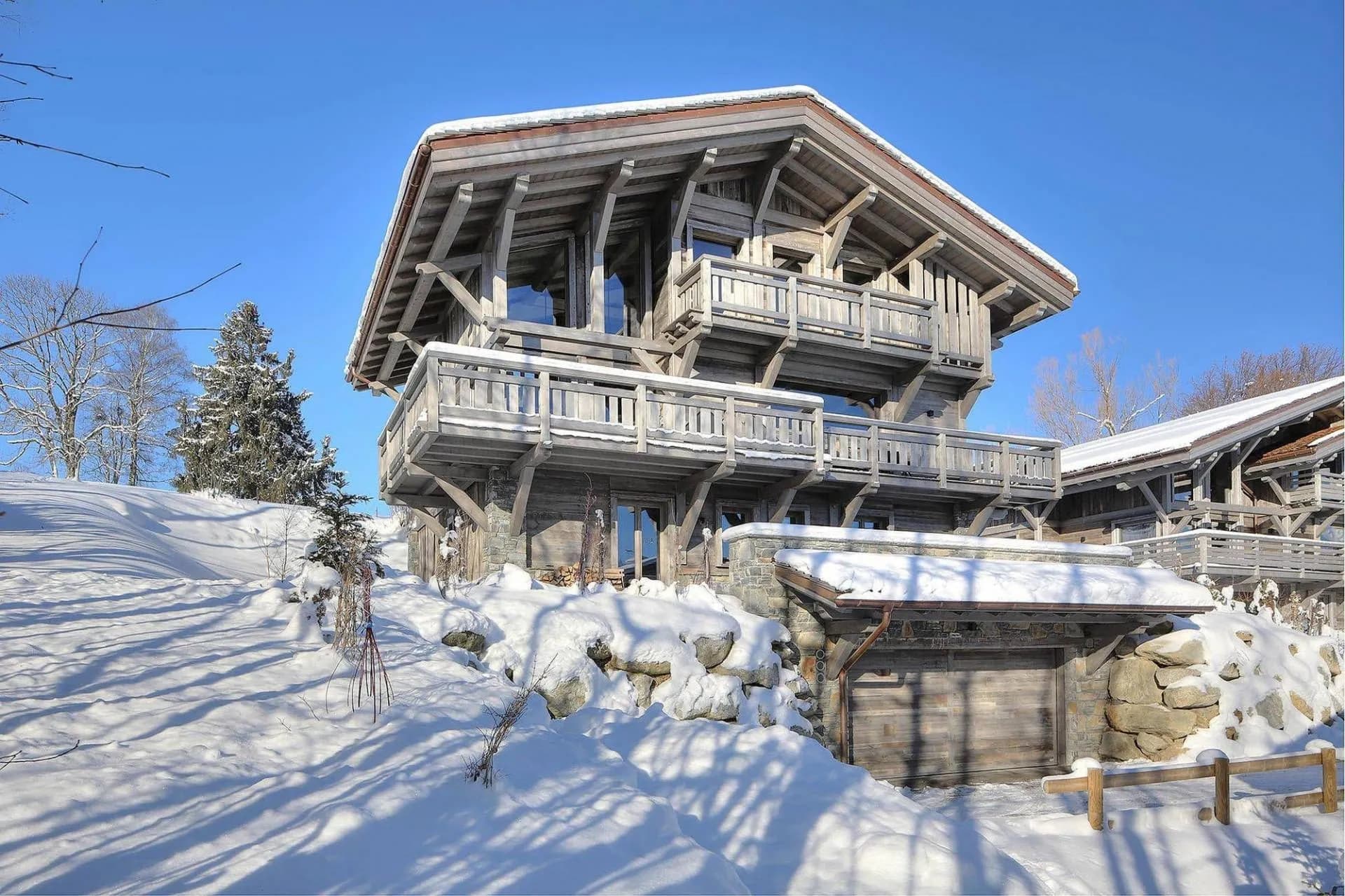 Chalet exterior and balconies above the snowy garden