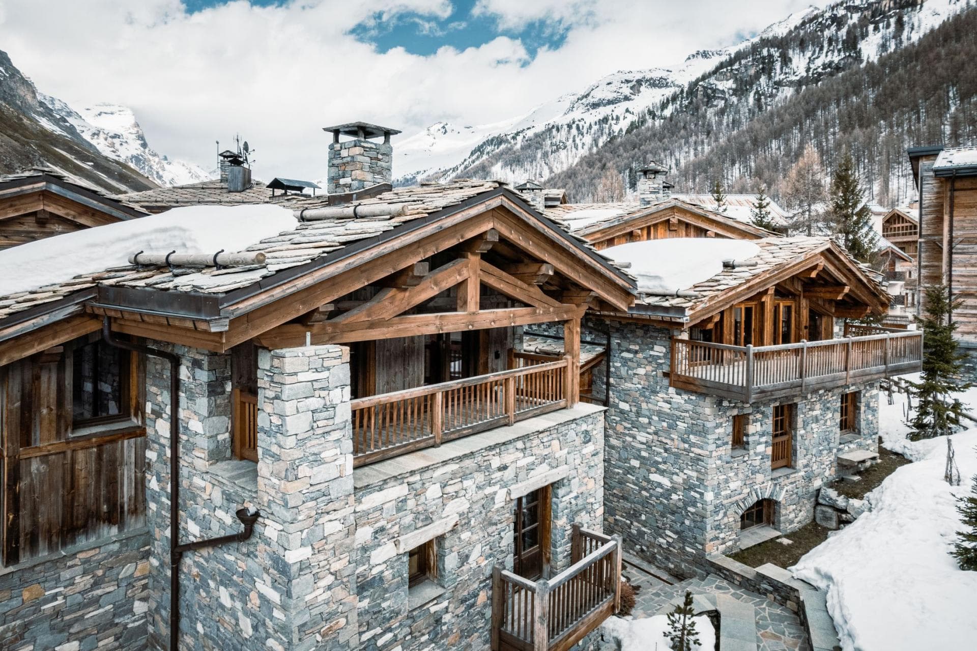 Stone and timber chalet exterior with private balconies and mountain views