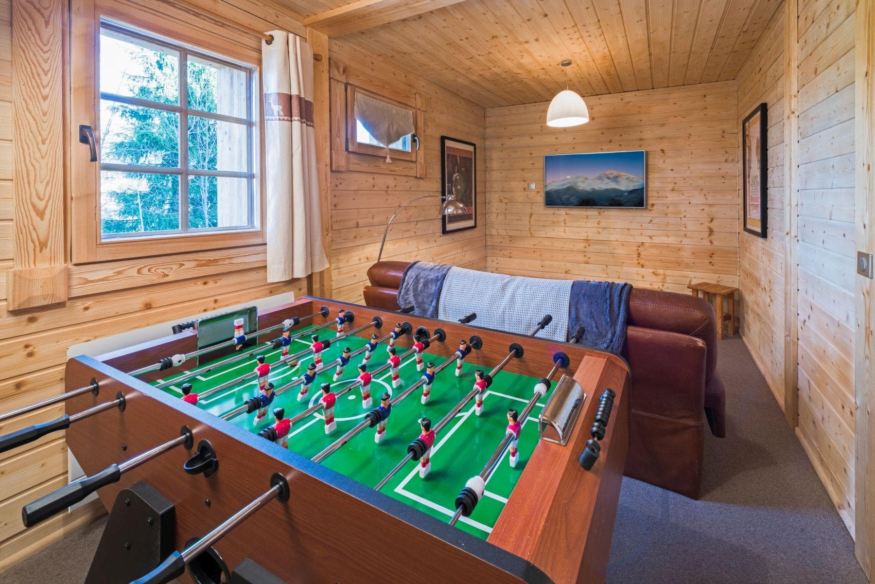 Game room with foosball table and wall-mounted TV