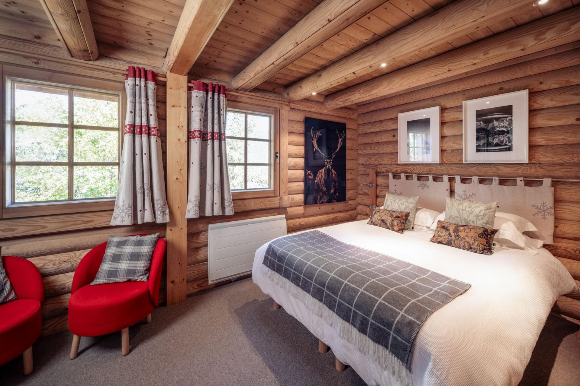 Log-cabin bedroom with king bed and exposed timber beams