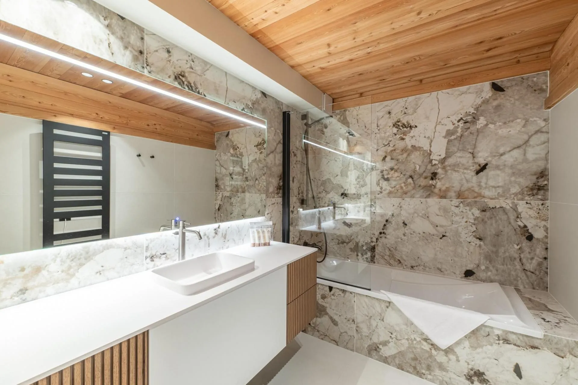 Bathroom with bathtub, heated towel rail and single basin