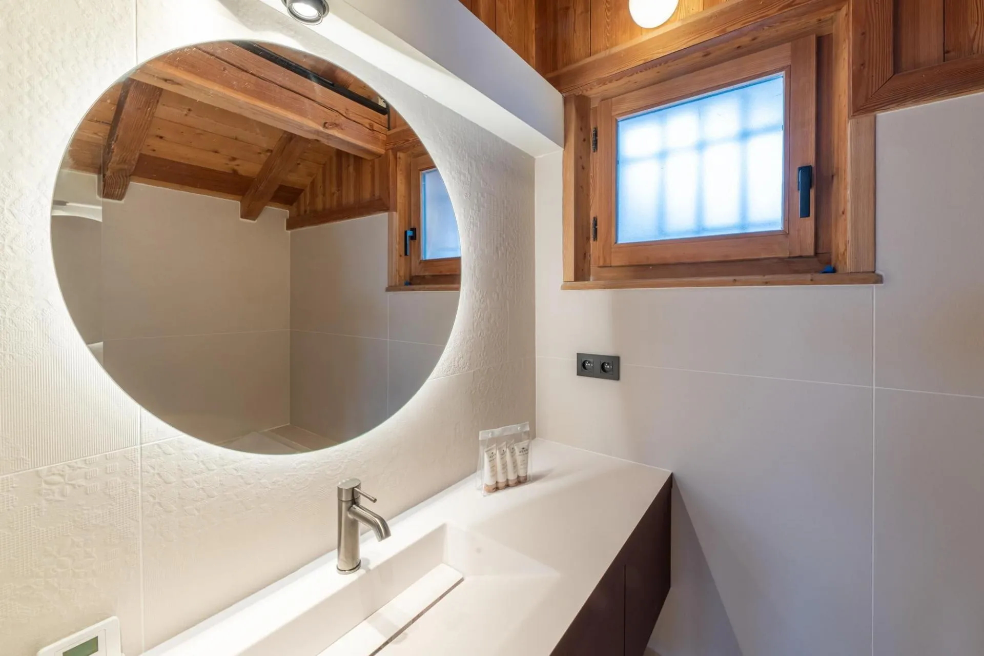 Bathroom vanity with illuminated mirror and privacy window