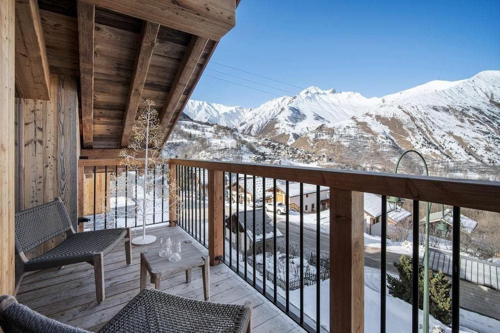 Covered balcony with lounge seating and panoramic alpine valley views