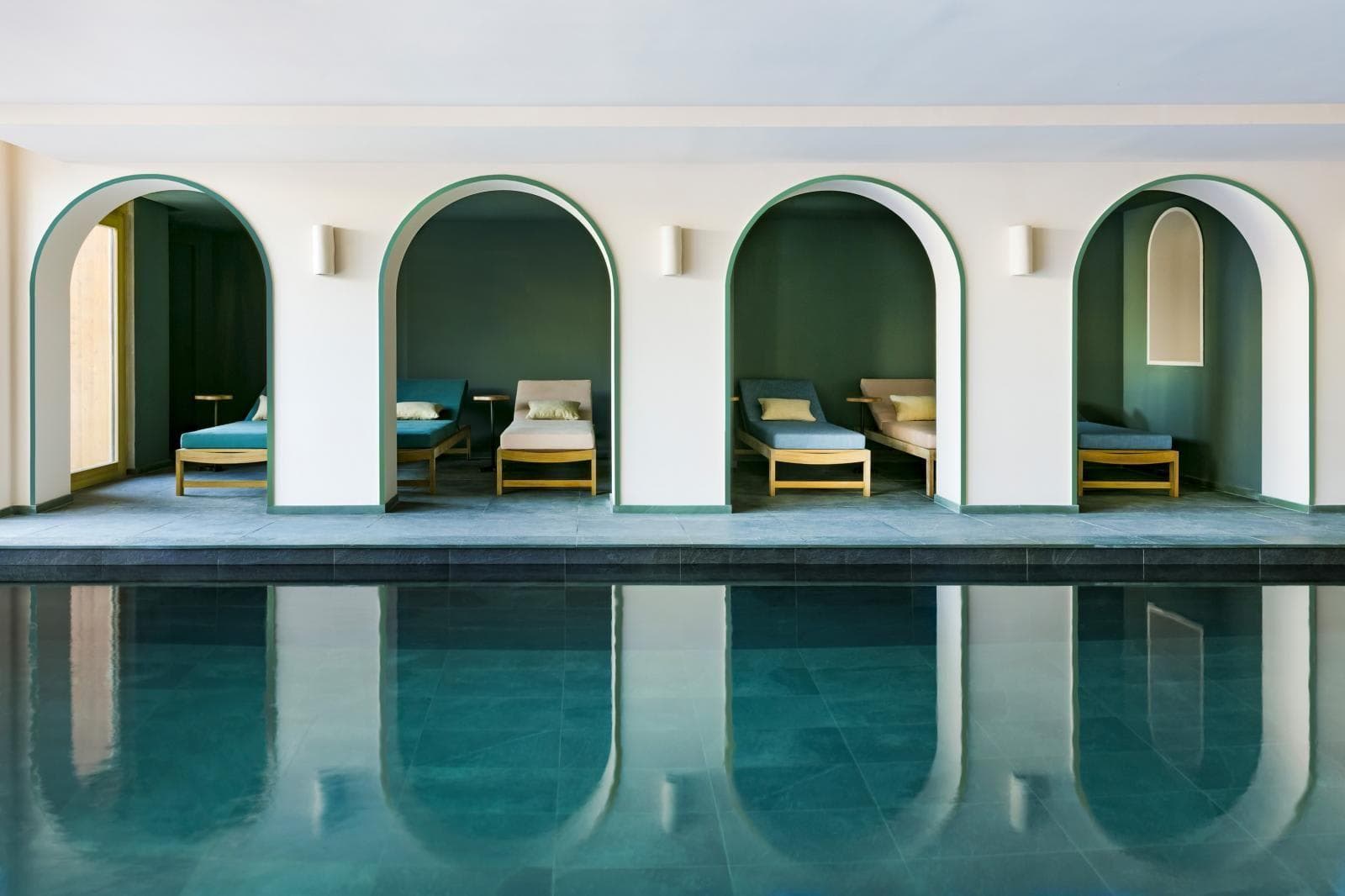 Indoor pool with recessed arched alcoves and lounge seating