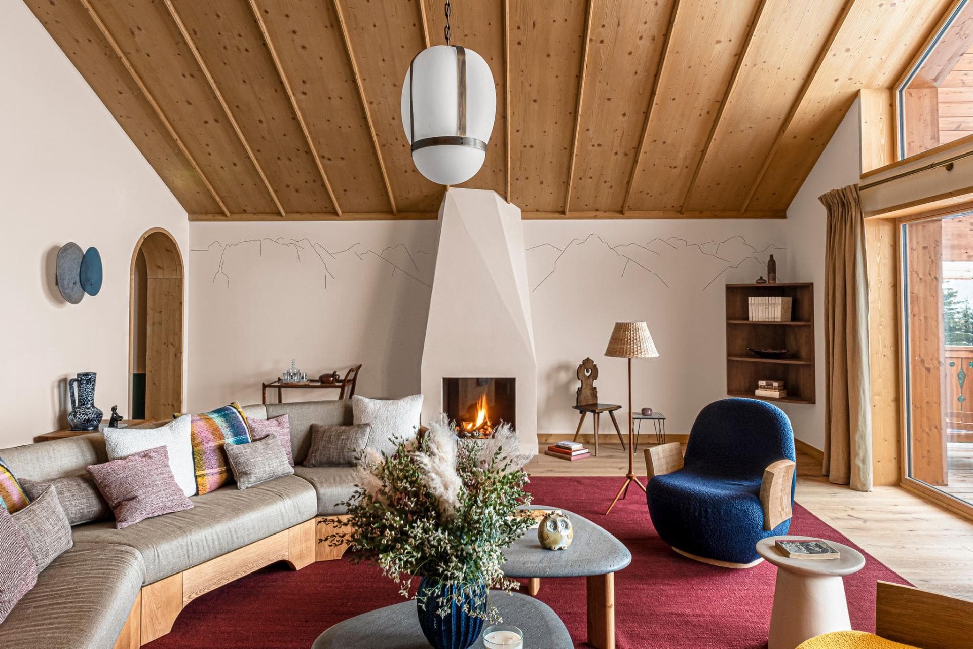 Living area with wood-clad vaulted ceiling and geometric wood-burning fireplace