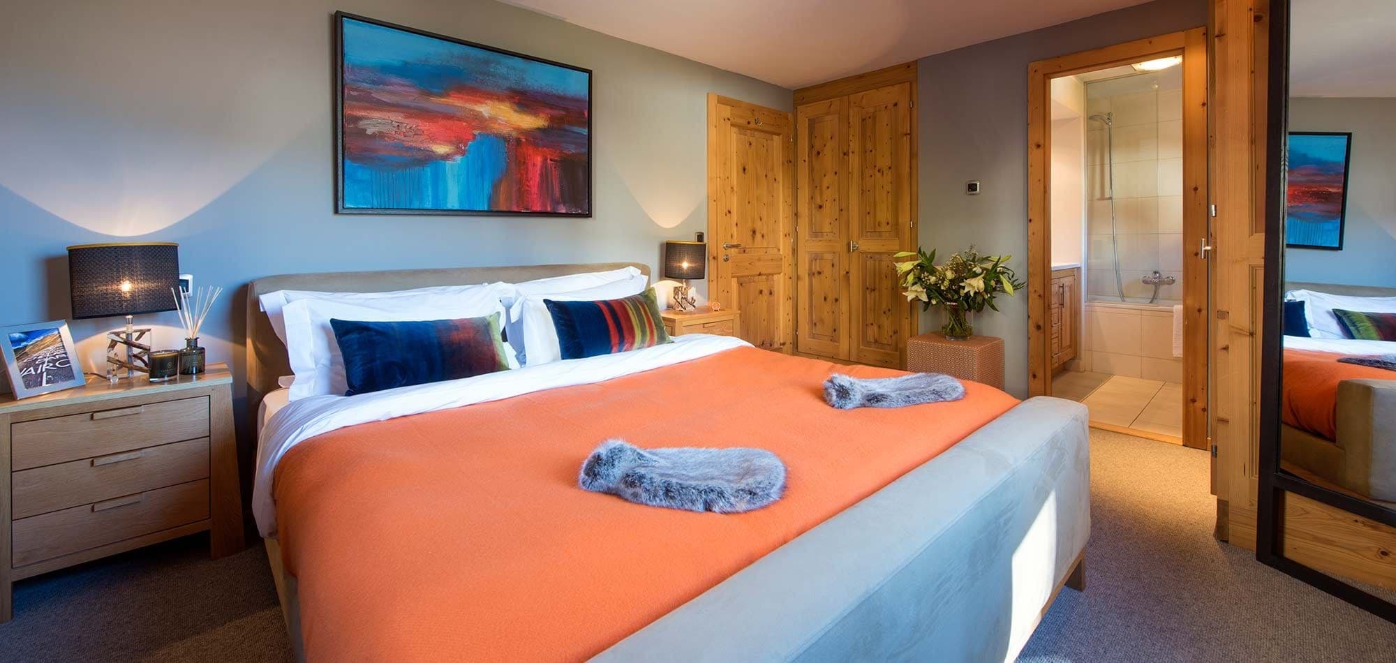 Primary bedroom with king bed, en-suite bathroom, and fitted wardrobes