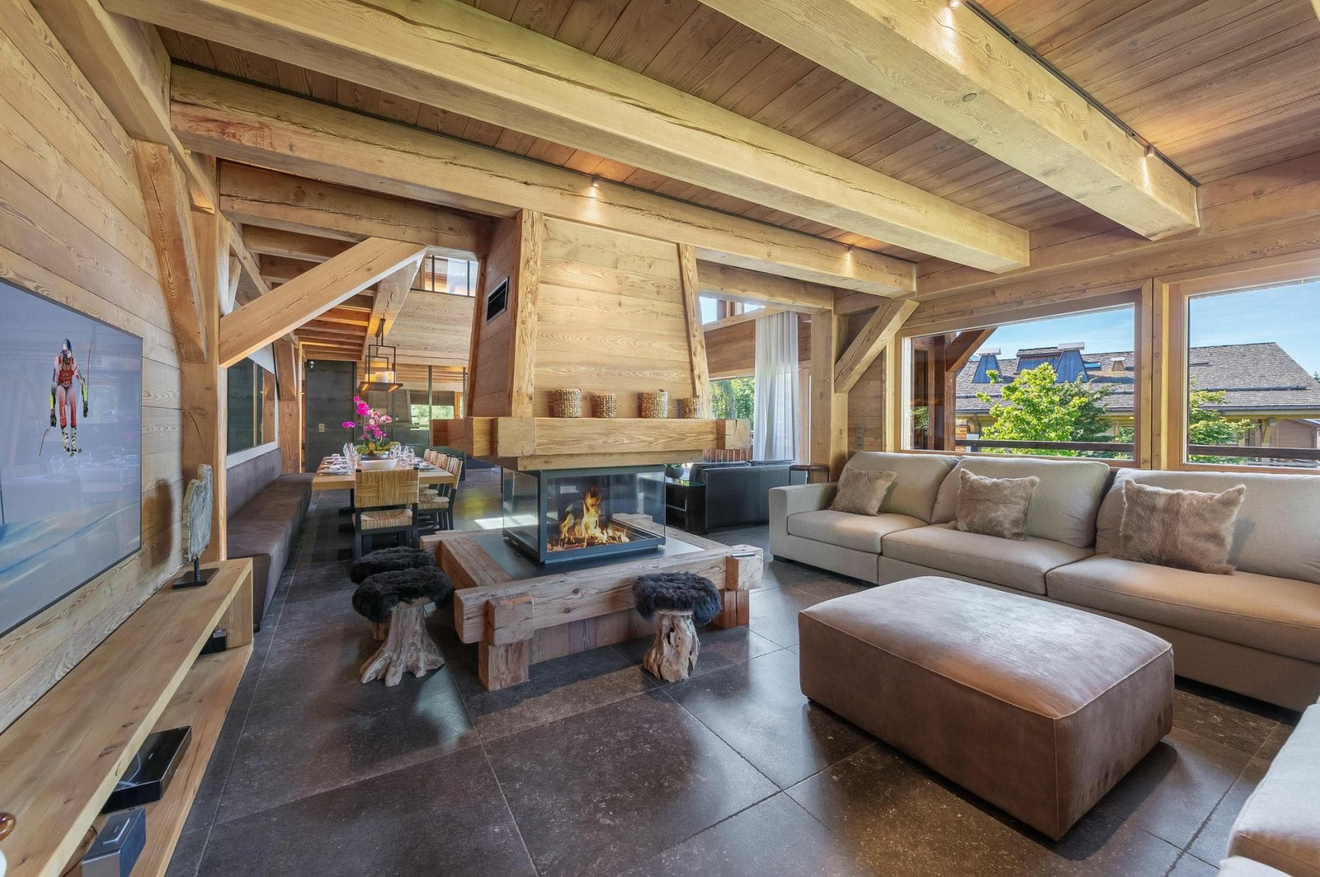 Living area with 360-degree glass fireplace and timber-beamed ceilings