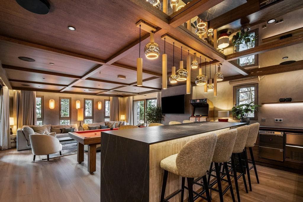 Entertainment room with pool table, arcade game, and bar seating for four