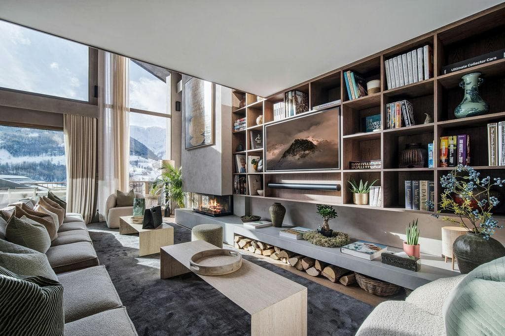 Living area with wood-burning fireplace and floor-to-ceiling mountain views