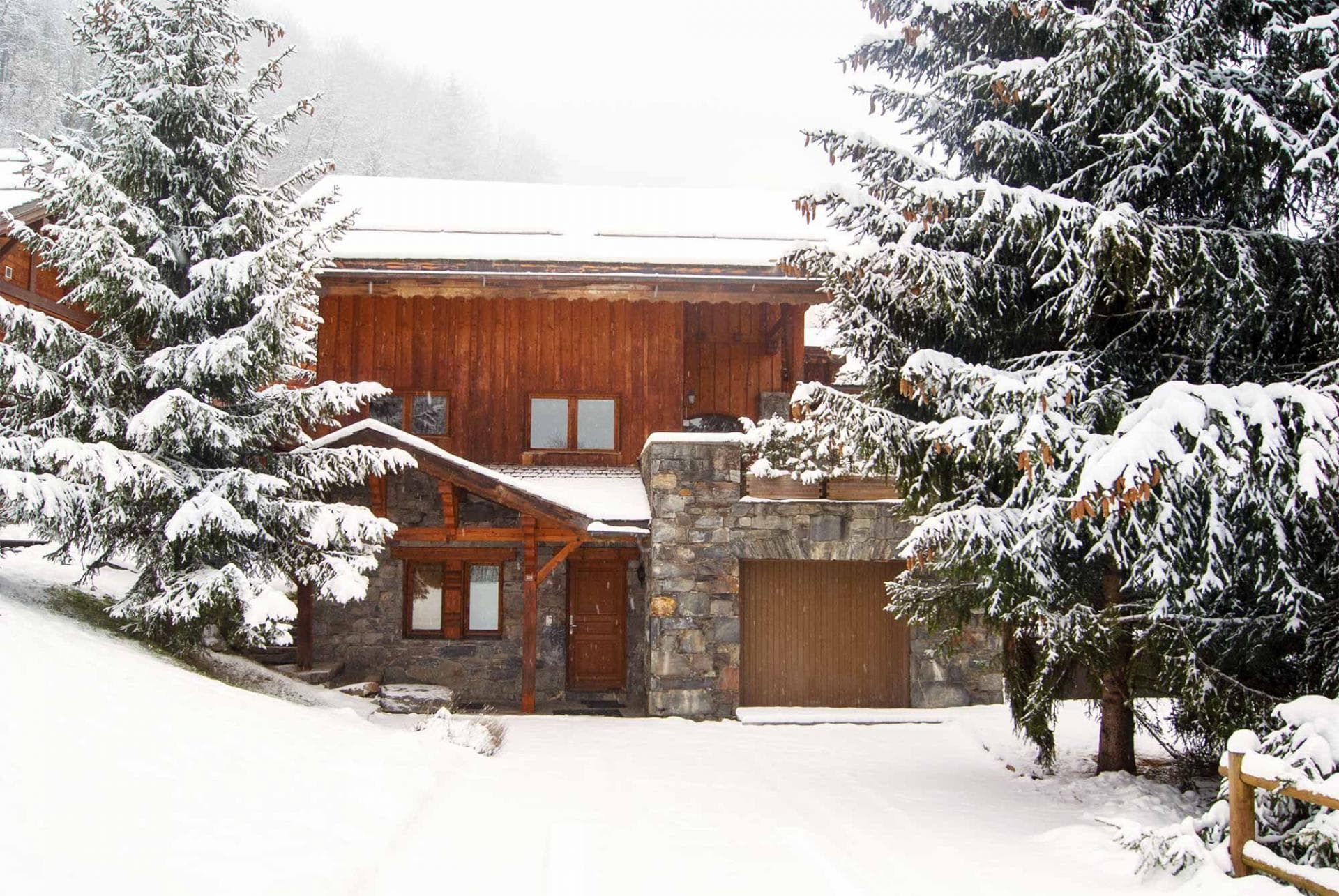 Chalet exterior featuring stone masonry and private garage parking