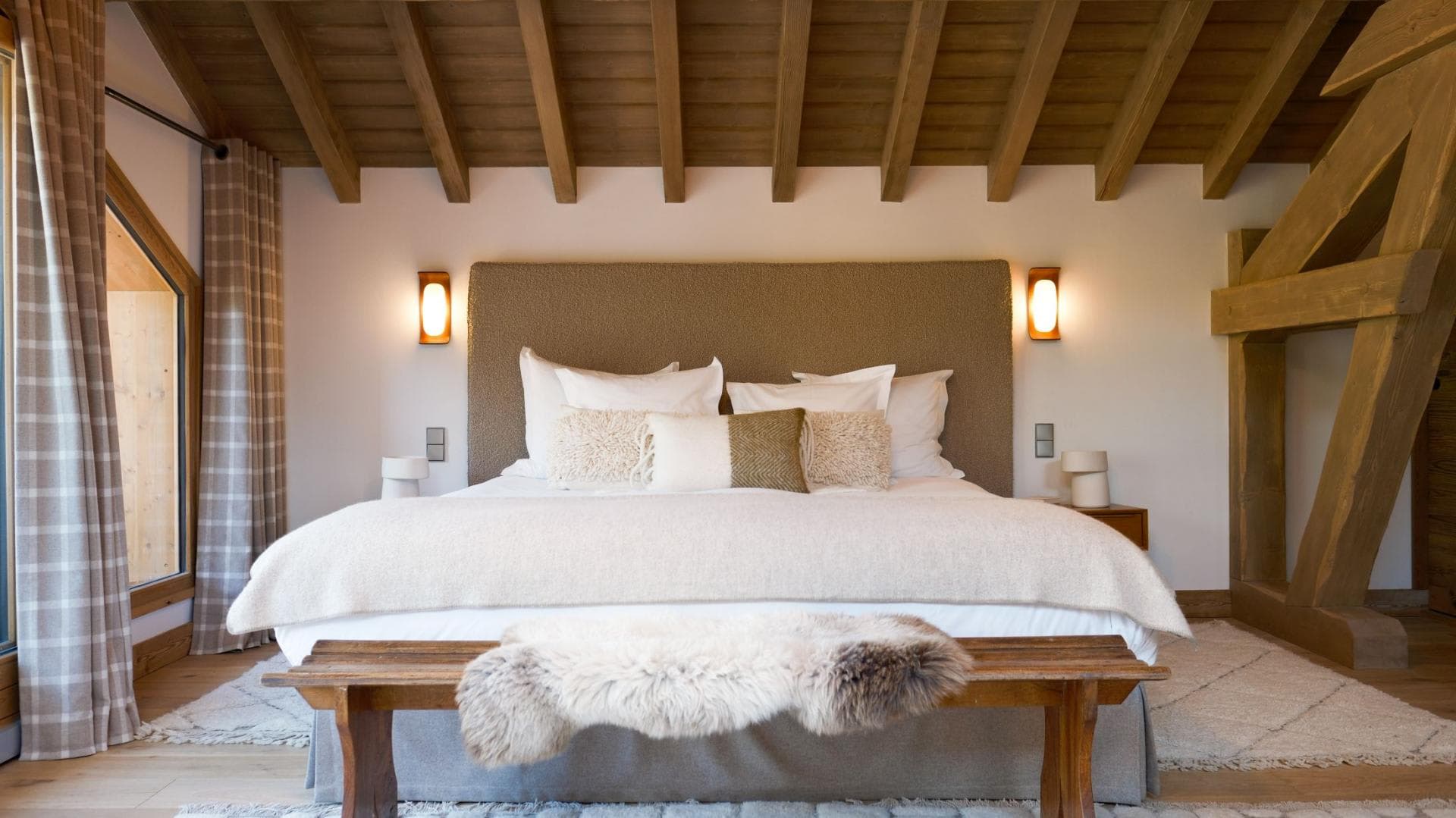 Primary bedroom with king bed and exposed timber ceiling beams