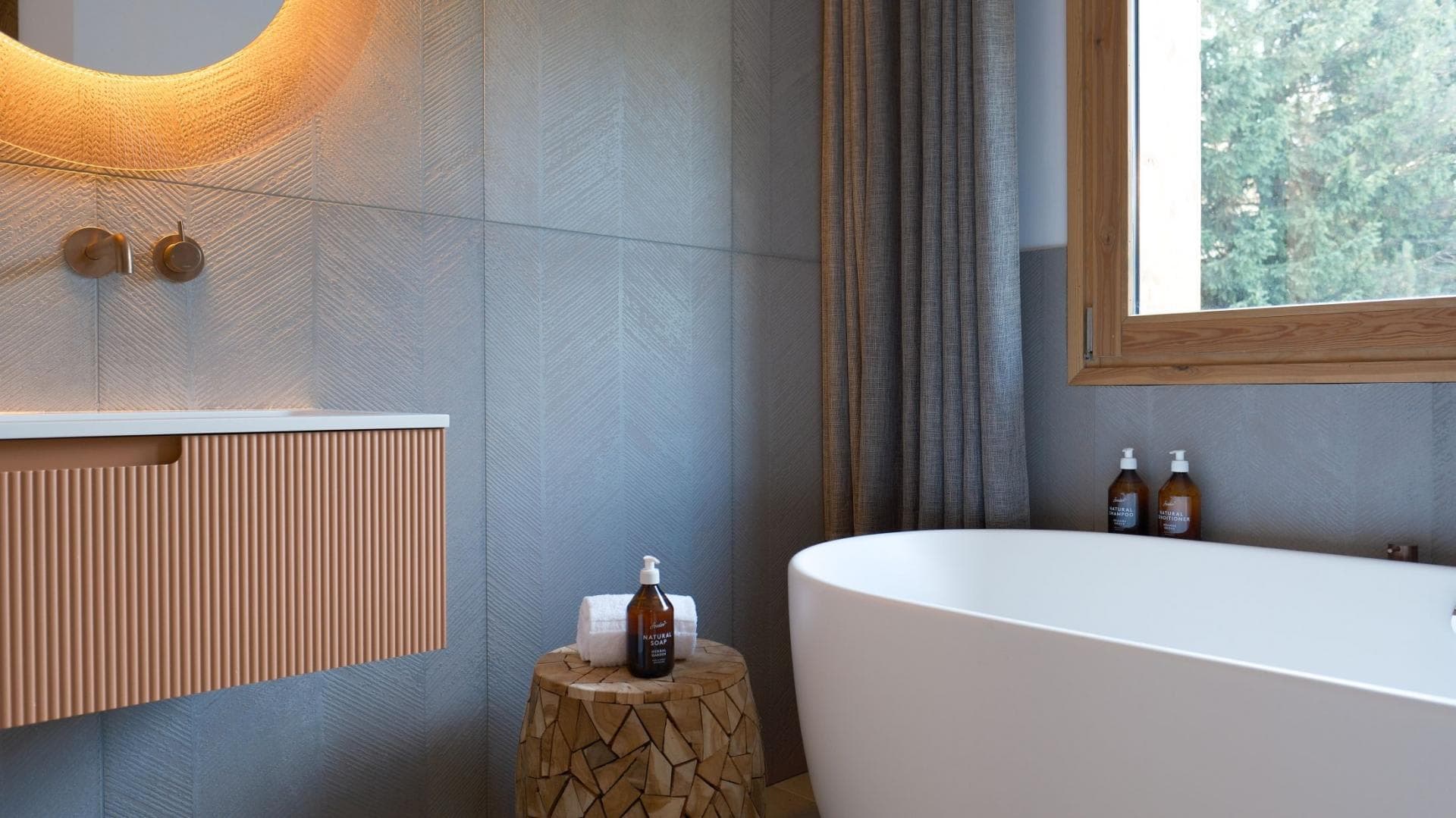 Bathroom with freestanding soaking tub and textured chevron wall tiles