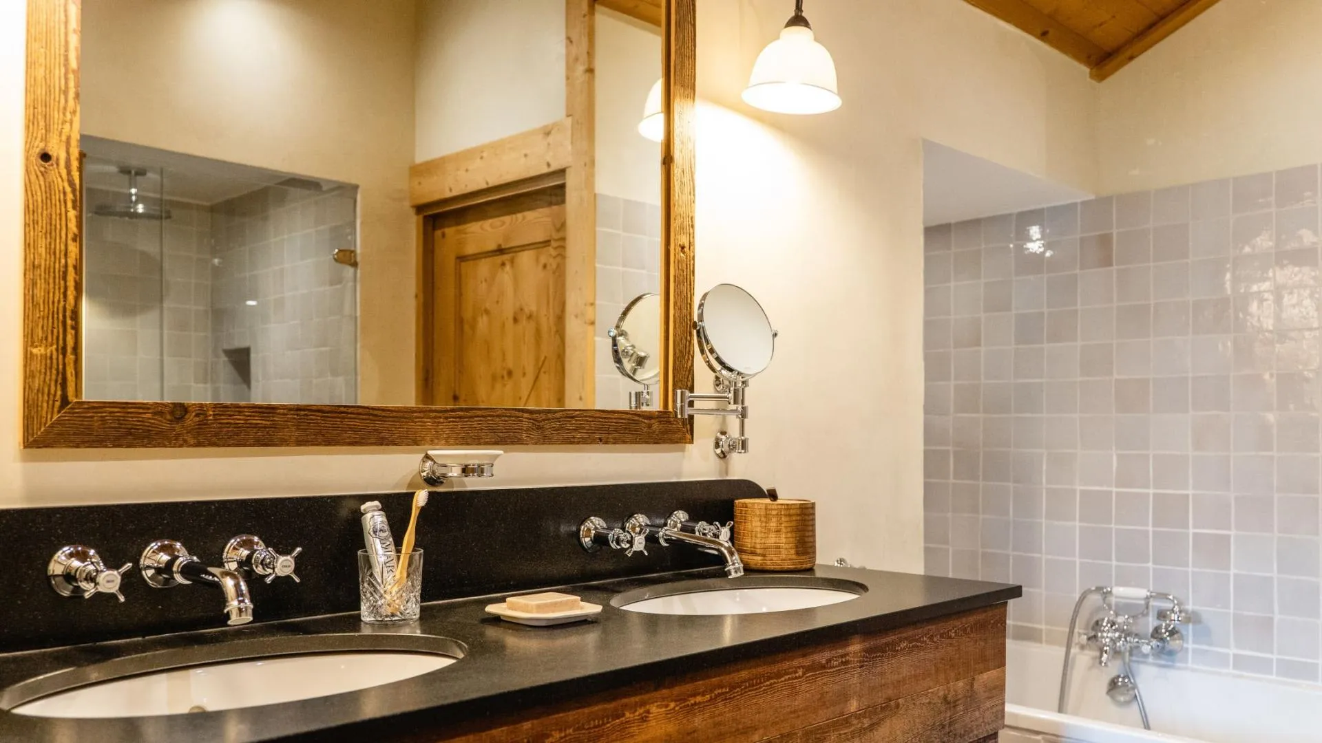 Bathroom with dual vanity, wall-mounted magnifying mirror, and soaking tub