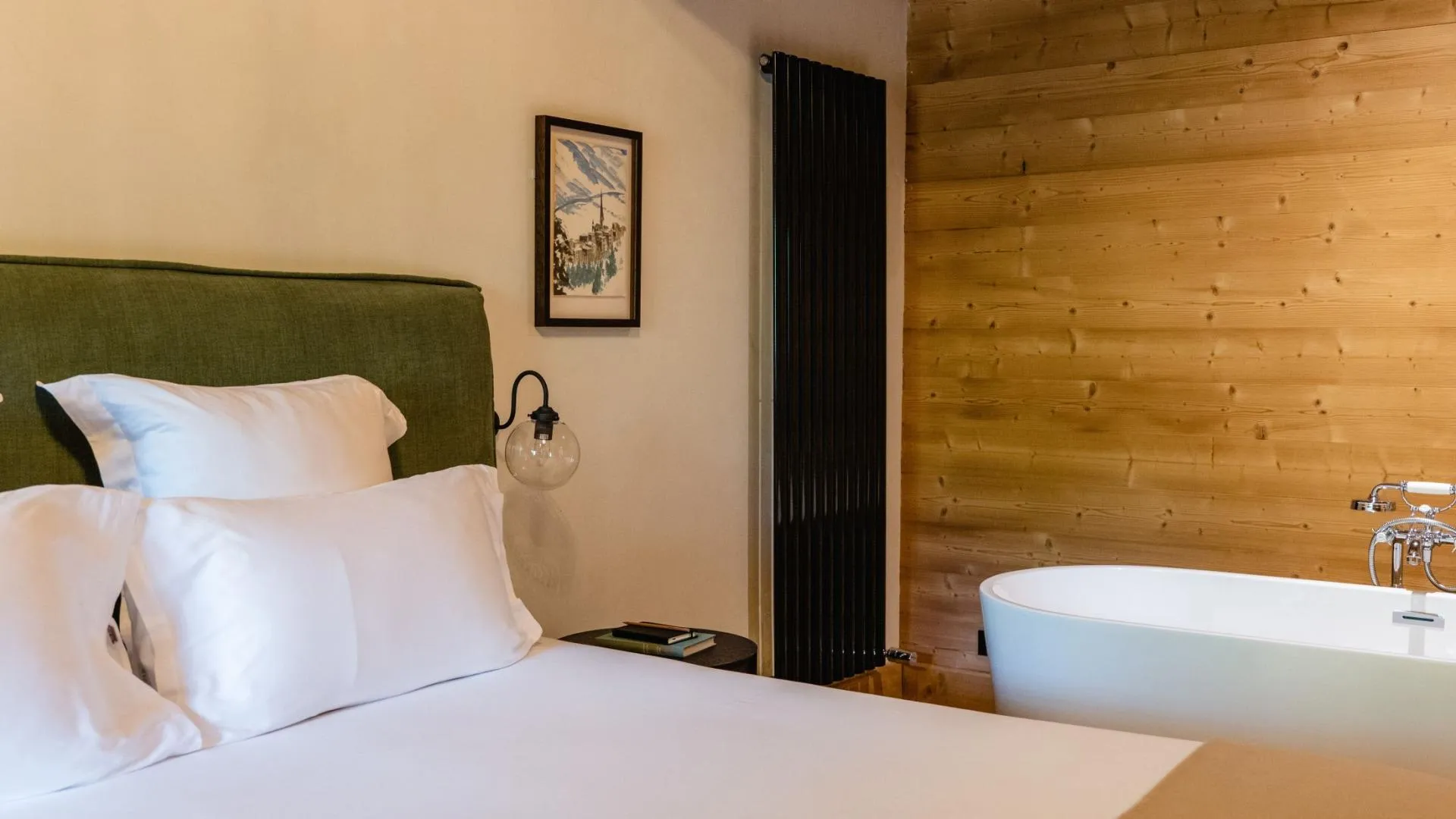 Guest bedroom featuring ensuite soaking tub and wood-paneled walls