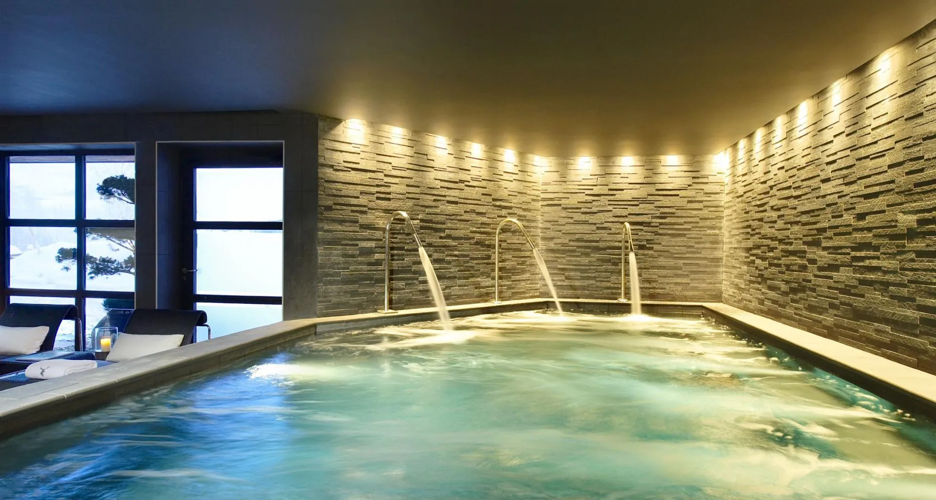 Indoor vitality pool with hydrotherapy massage jets and stone wall