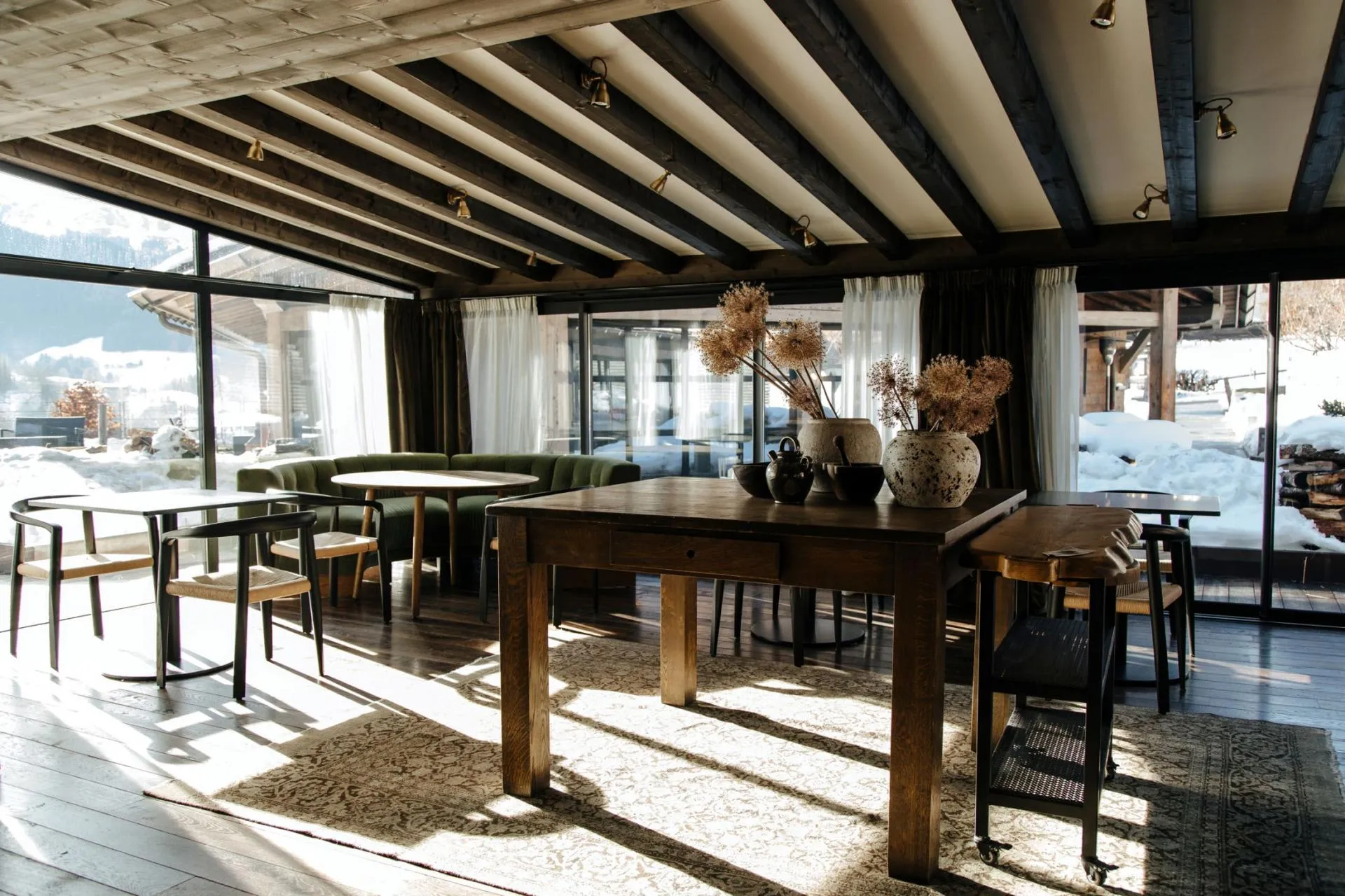 Dining area with booth seating and floor-to-ceiling windows overlooking snow