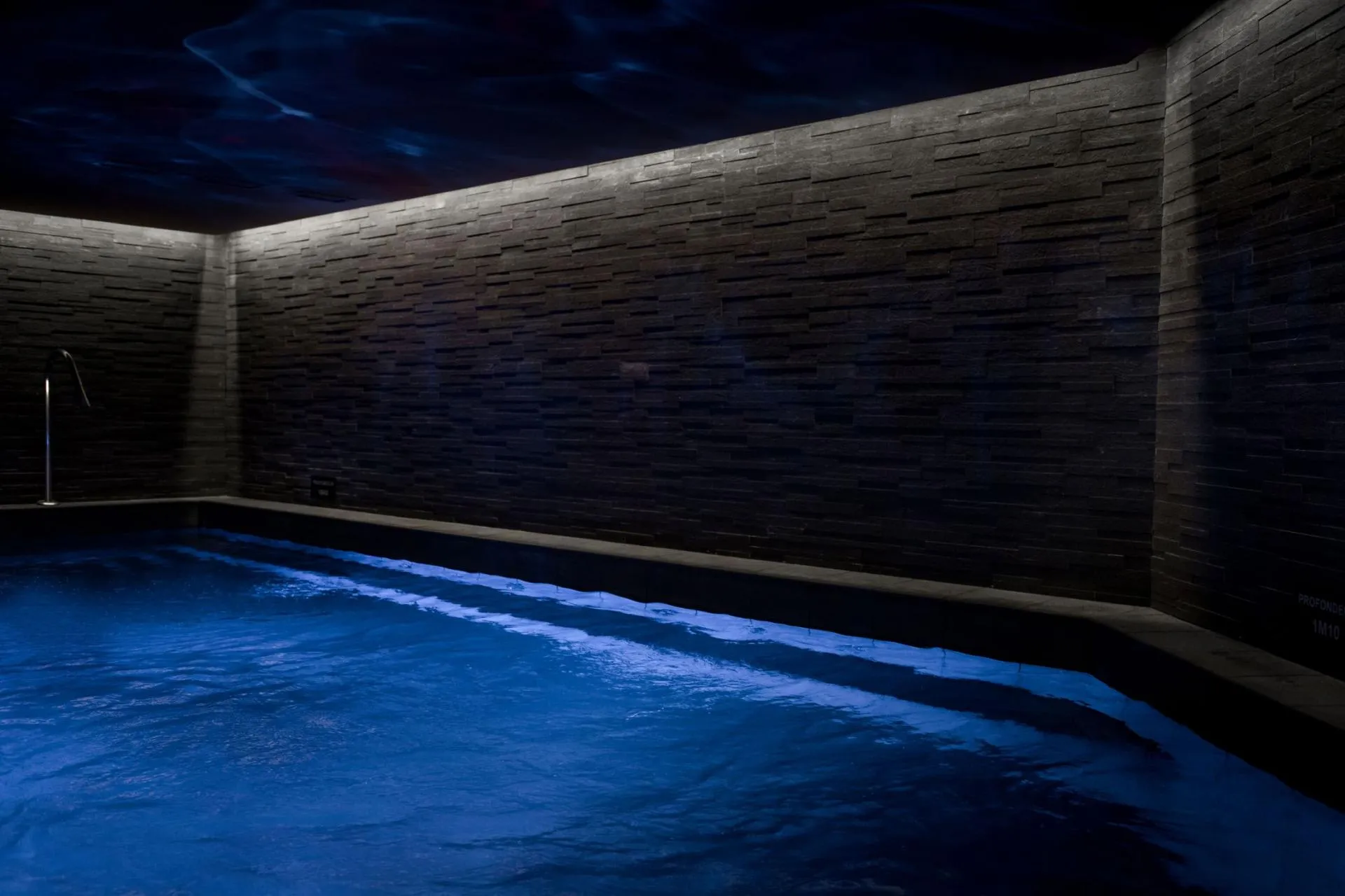 Indoor pool with slate tile walls and 1.1 meter depth