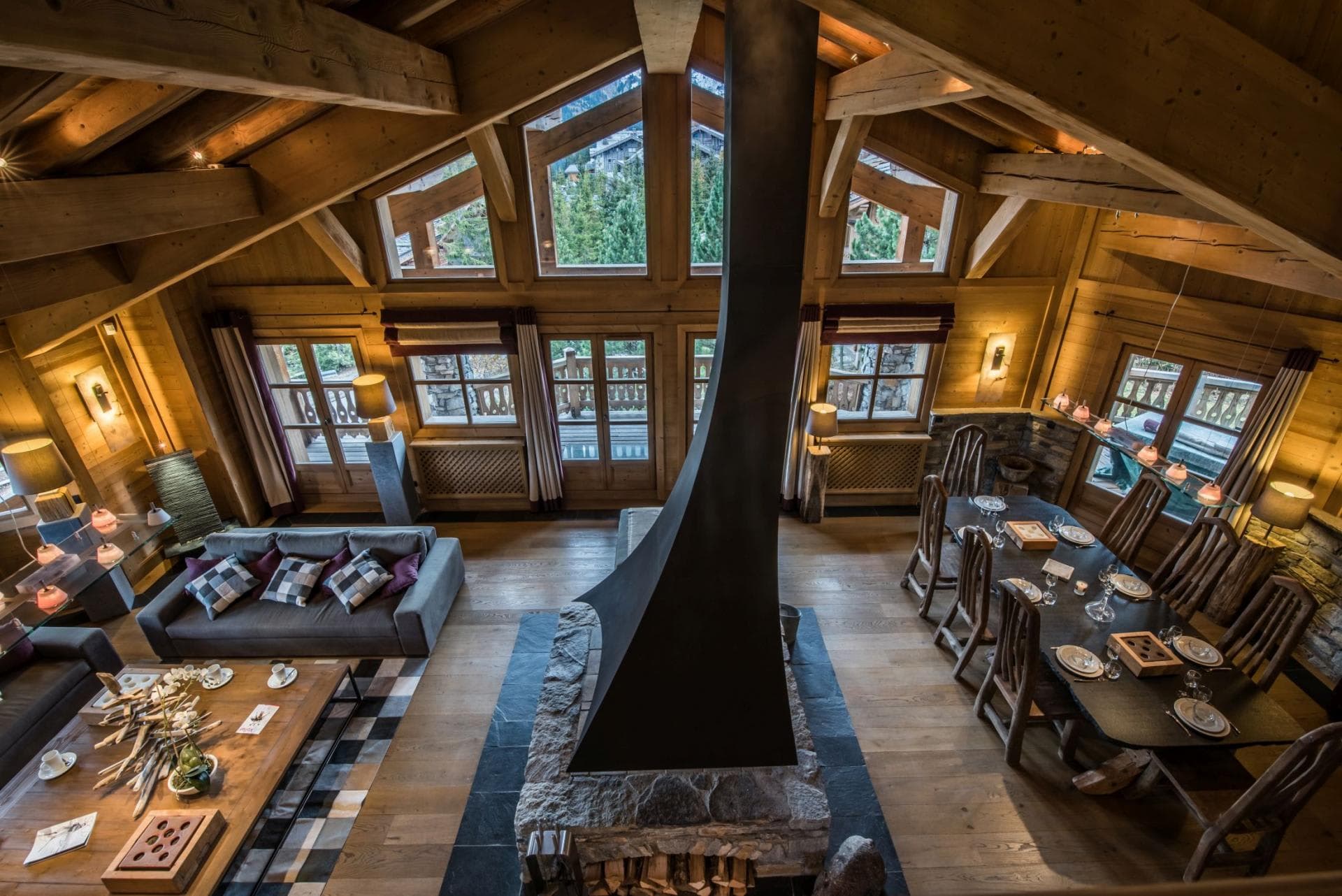 Open-plan living area with central wood-burning fireplace and dining for 10