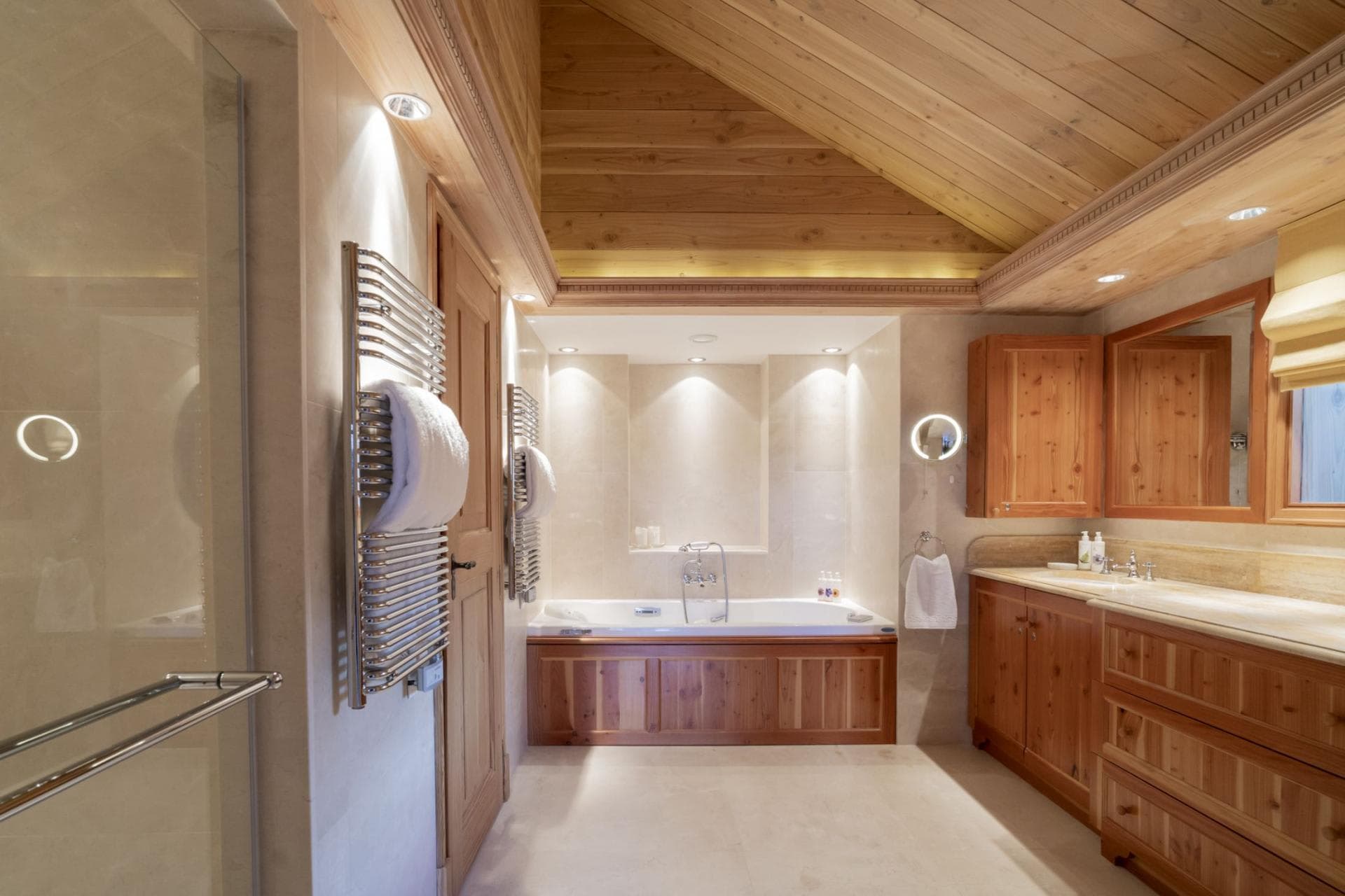 Bathroom with soaking tub, walk-in shower, and heated towel rails