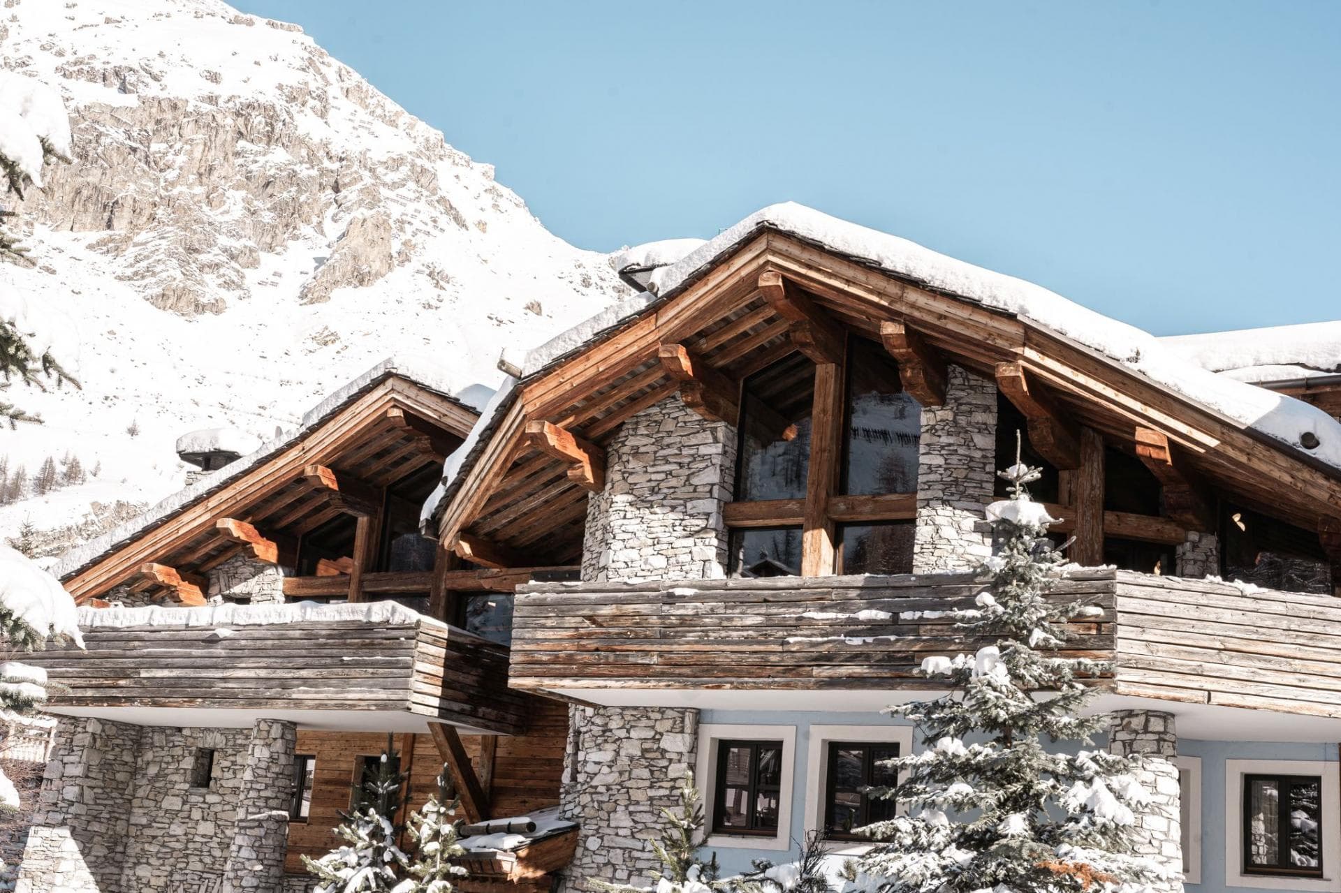 Ski-in chalet exterior with stone facade and private timber balconies