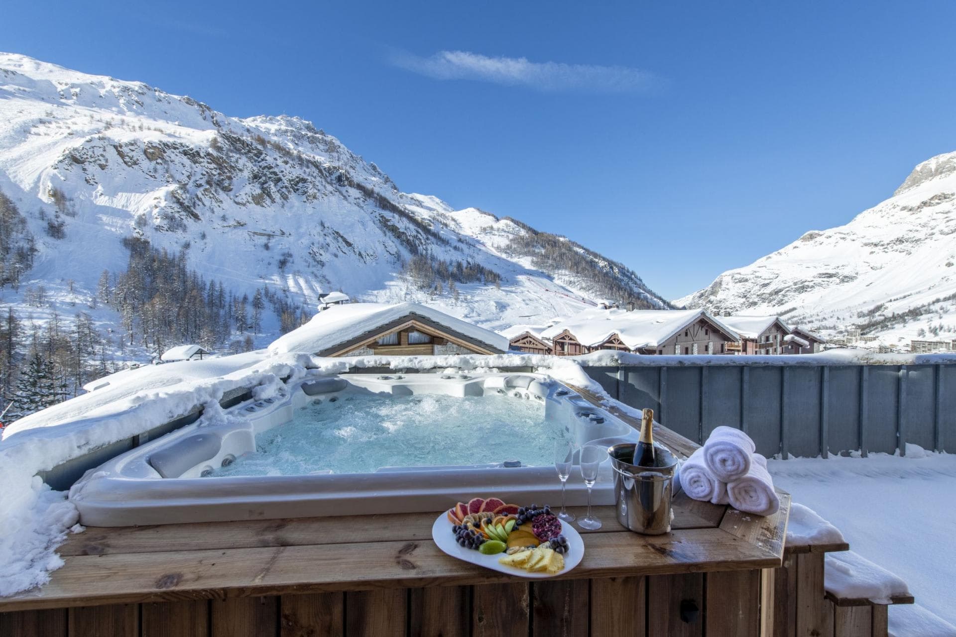 Outdoor hot tub with panoramic mountain and ski village views