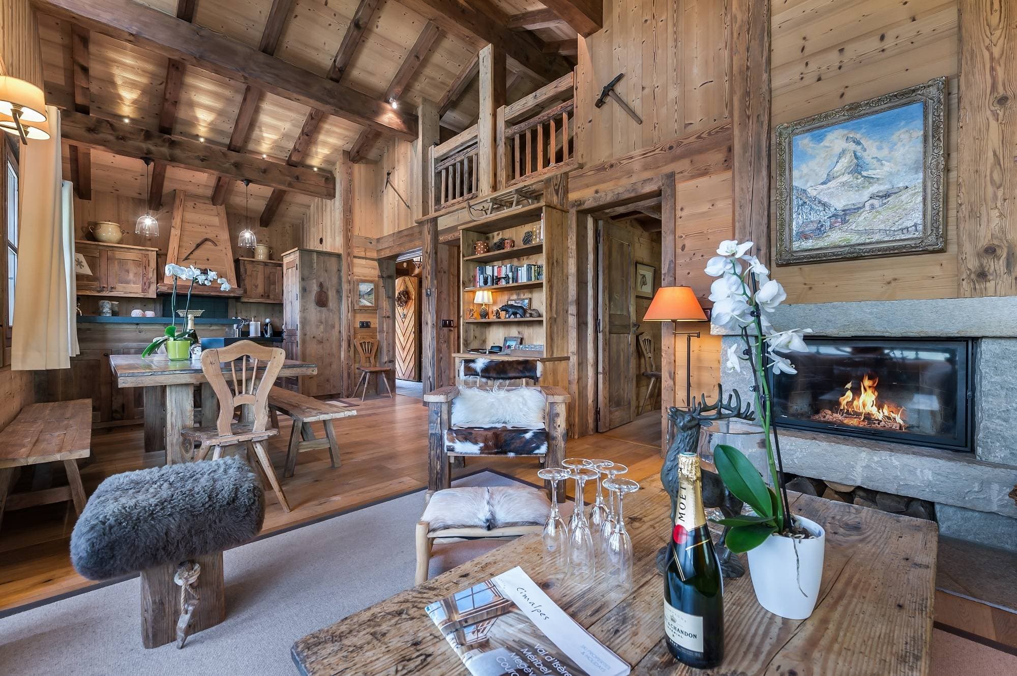 Open-plan living area with wood-burning fireplace and vaulted timber ceilings