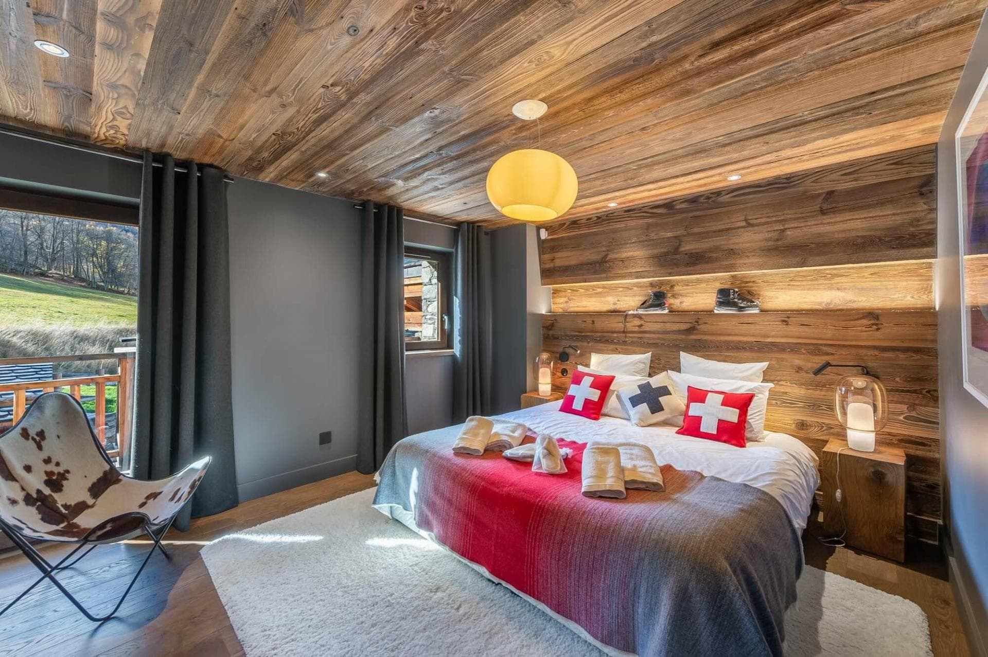 Bedroom with king bed, reclaimed wood walls, and private balcony access