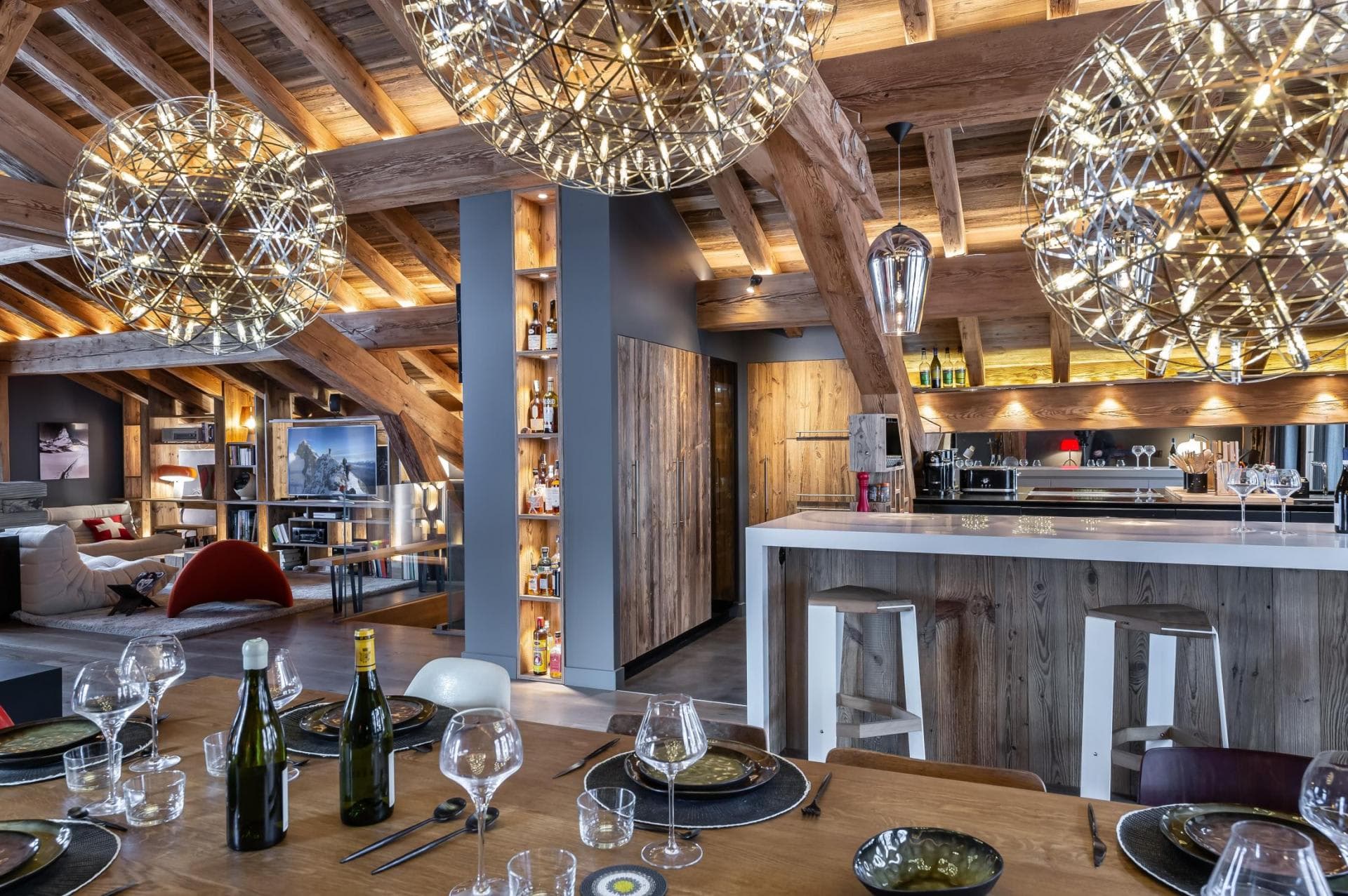 Open-plan dining area and kitchen with breakfast bar and exposed timber beams