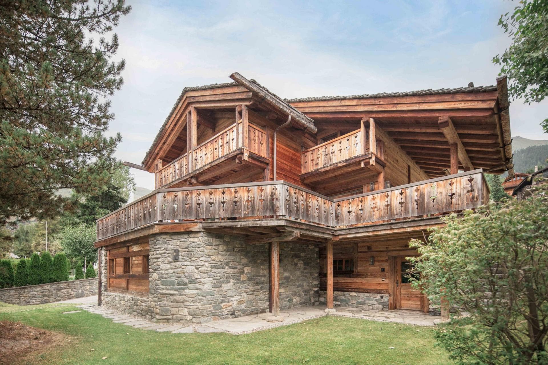Timber and stone chalet exterior with multi-level wrap-around balconies