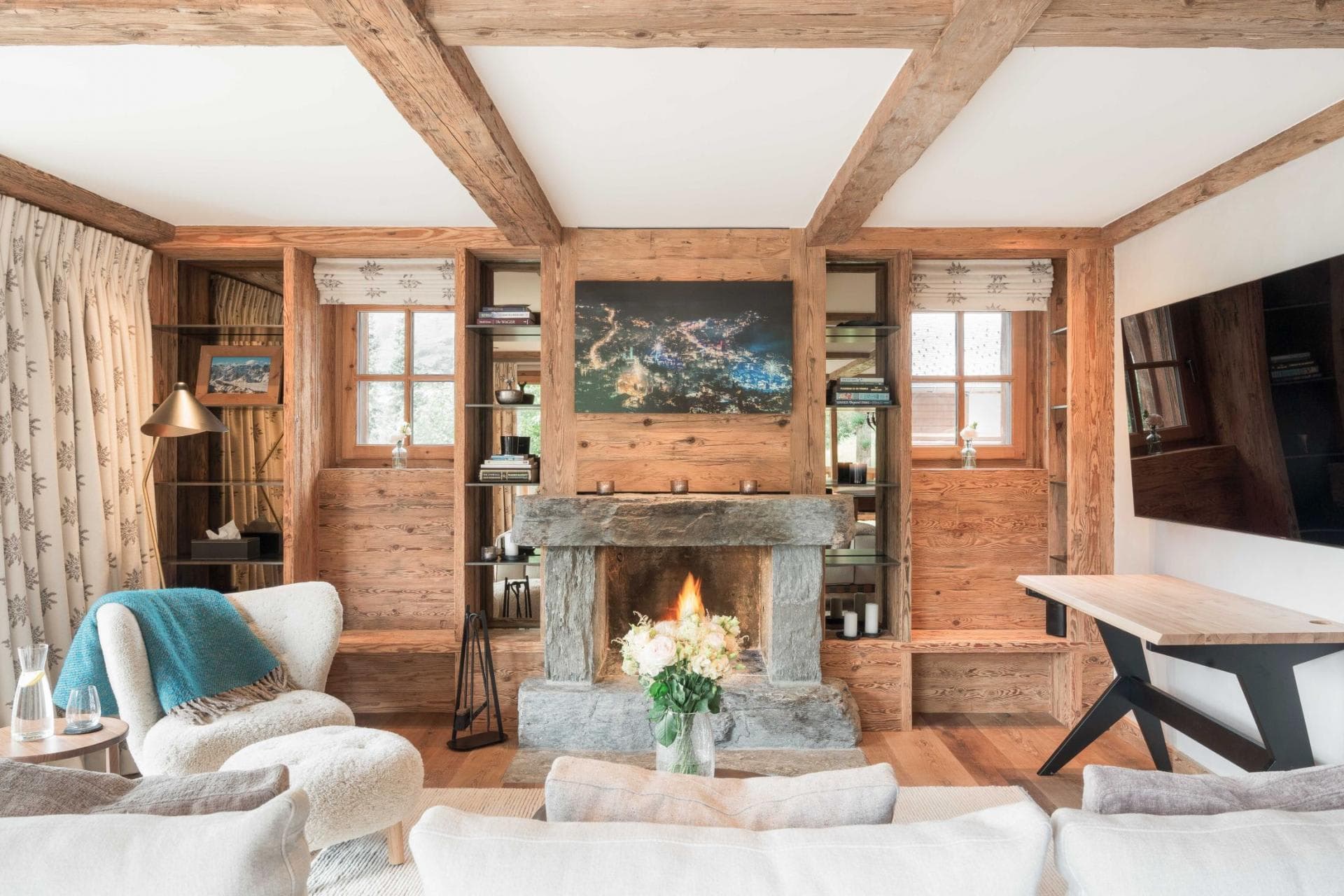 Living area with wood-burning stone fireplace and integrated workspace
