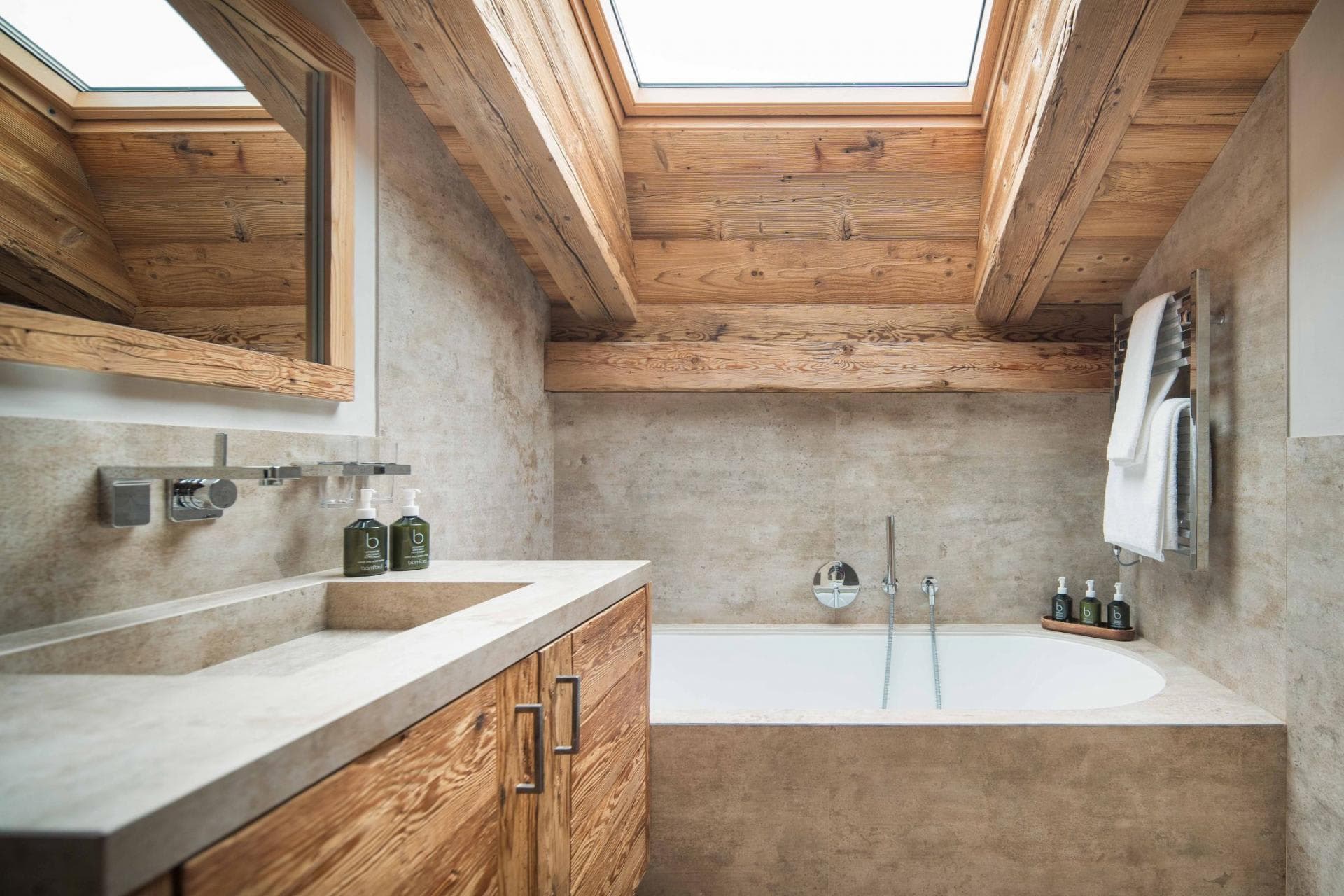 Bathroom with soaking tub, heated towel rail, and skylight