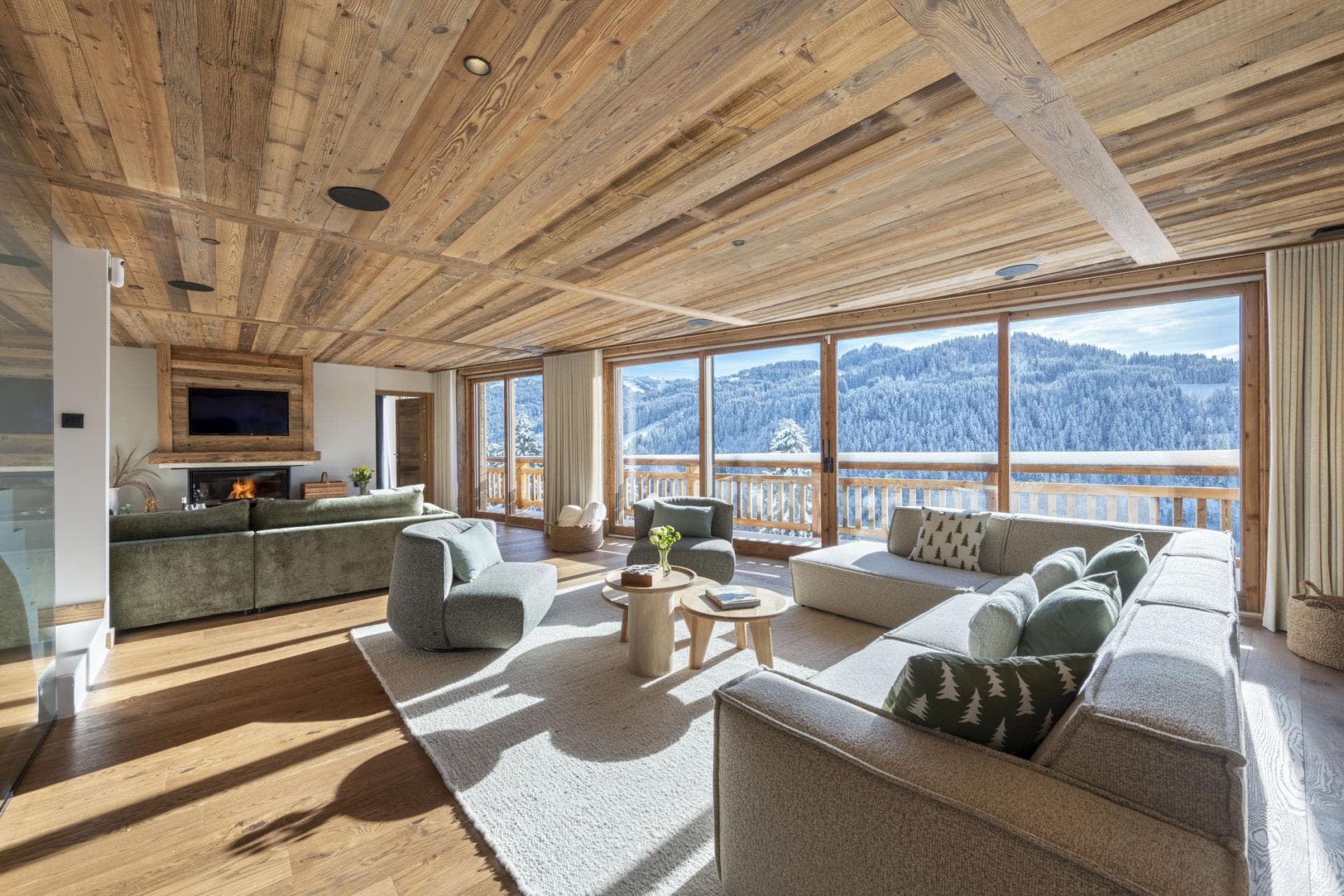 Living area with wood-clad ceiling, fireplace, and floor-to-ceiling mountain views