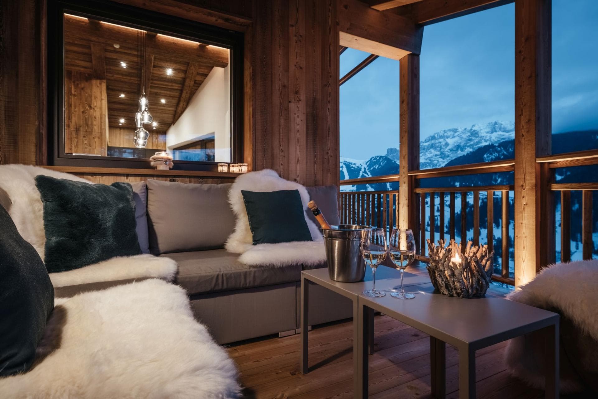 Covered balcony with sectional seating and alpine mountain views