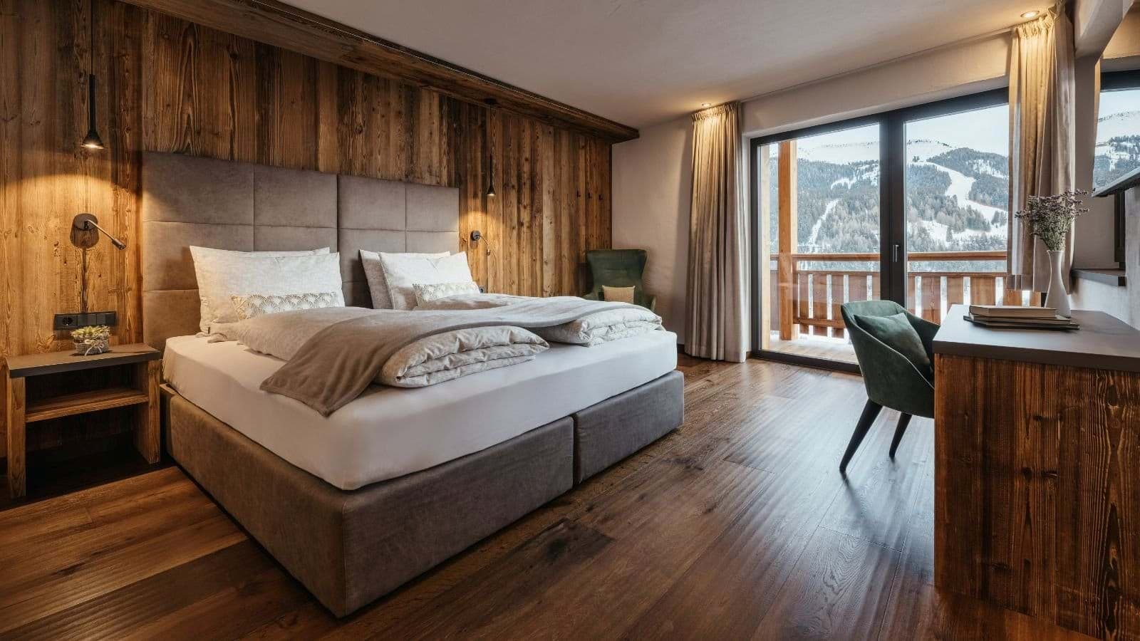 Primary bedroom with king bed and balcony access overlooking ski slopes